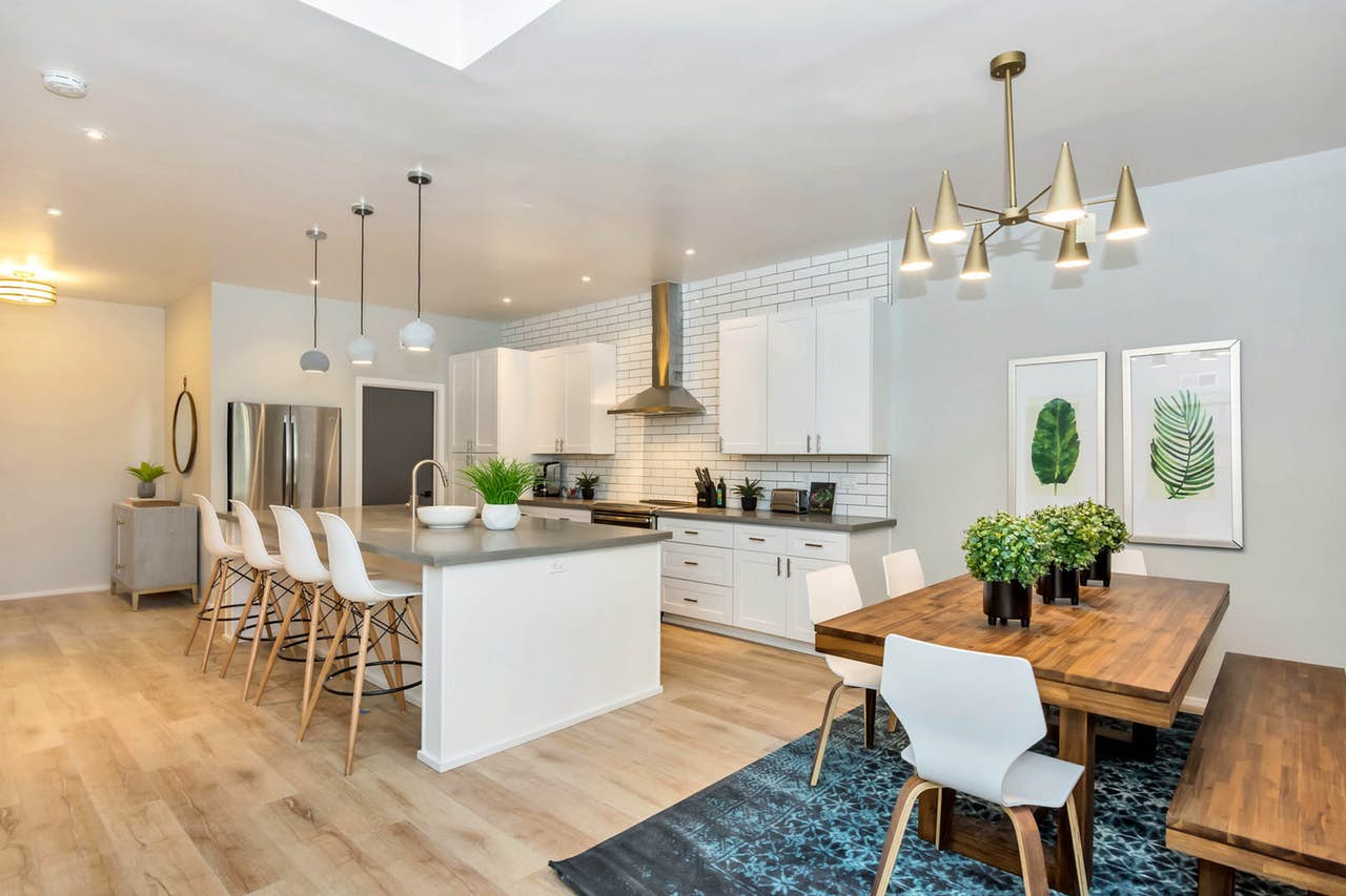 modern kitchen with white cabinets and backsplash and faux greenery accents