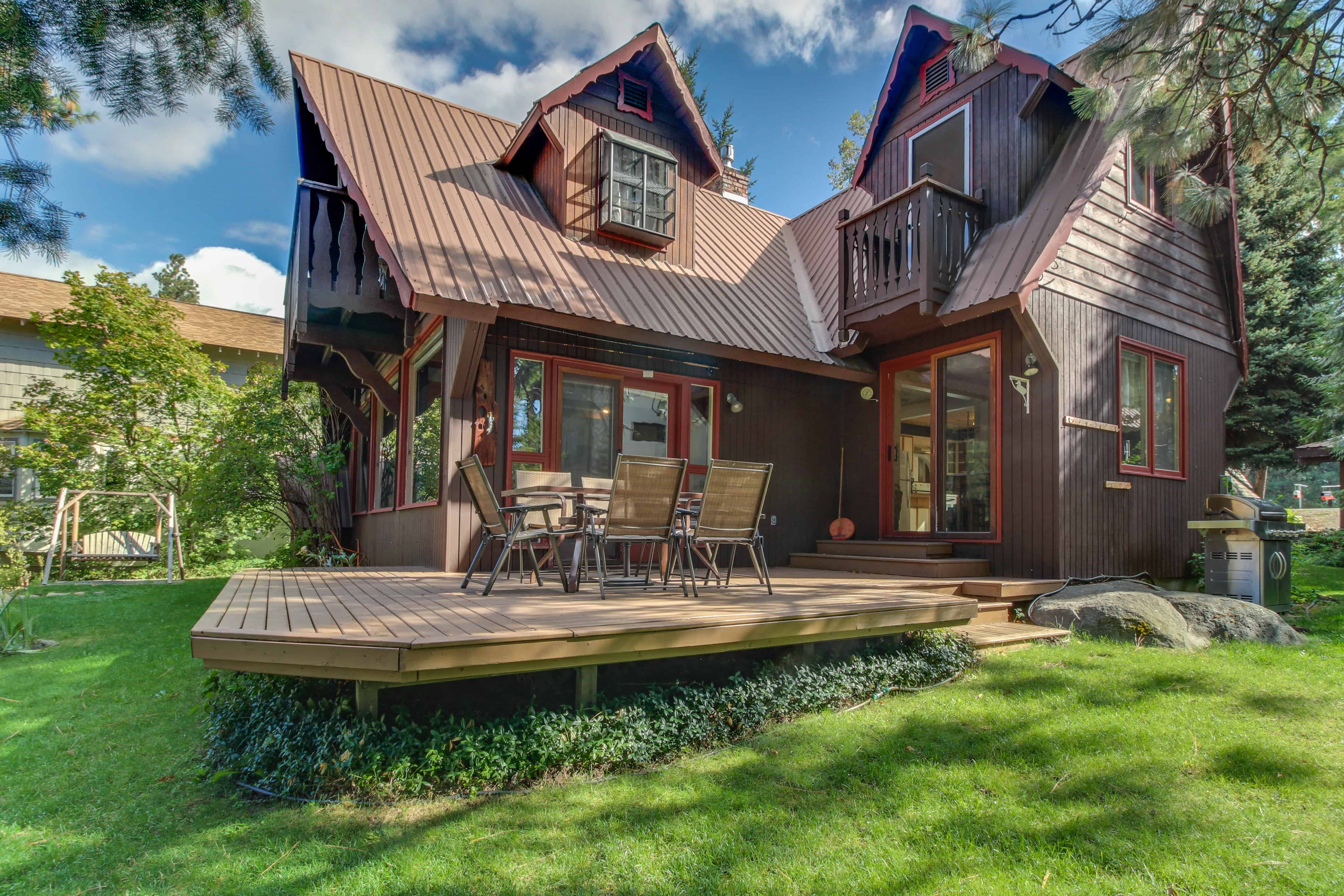 Back yard of a vacation rental in Leavenworth, WA with a large deck and a swing.