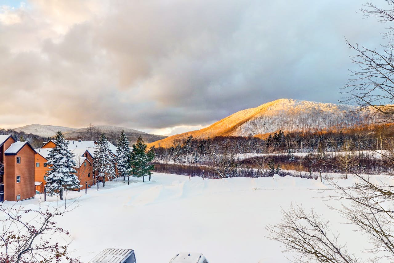 view of condo buildings and snow-covered mountains in Killington, VT