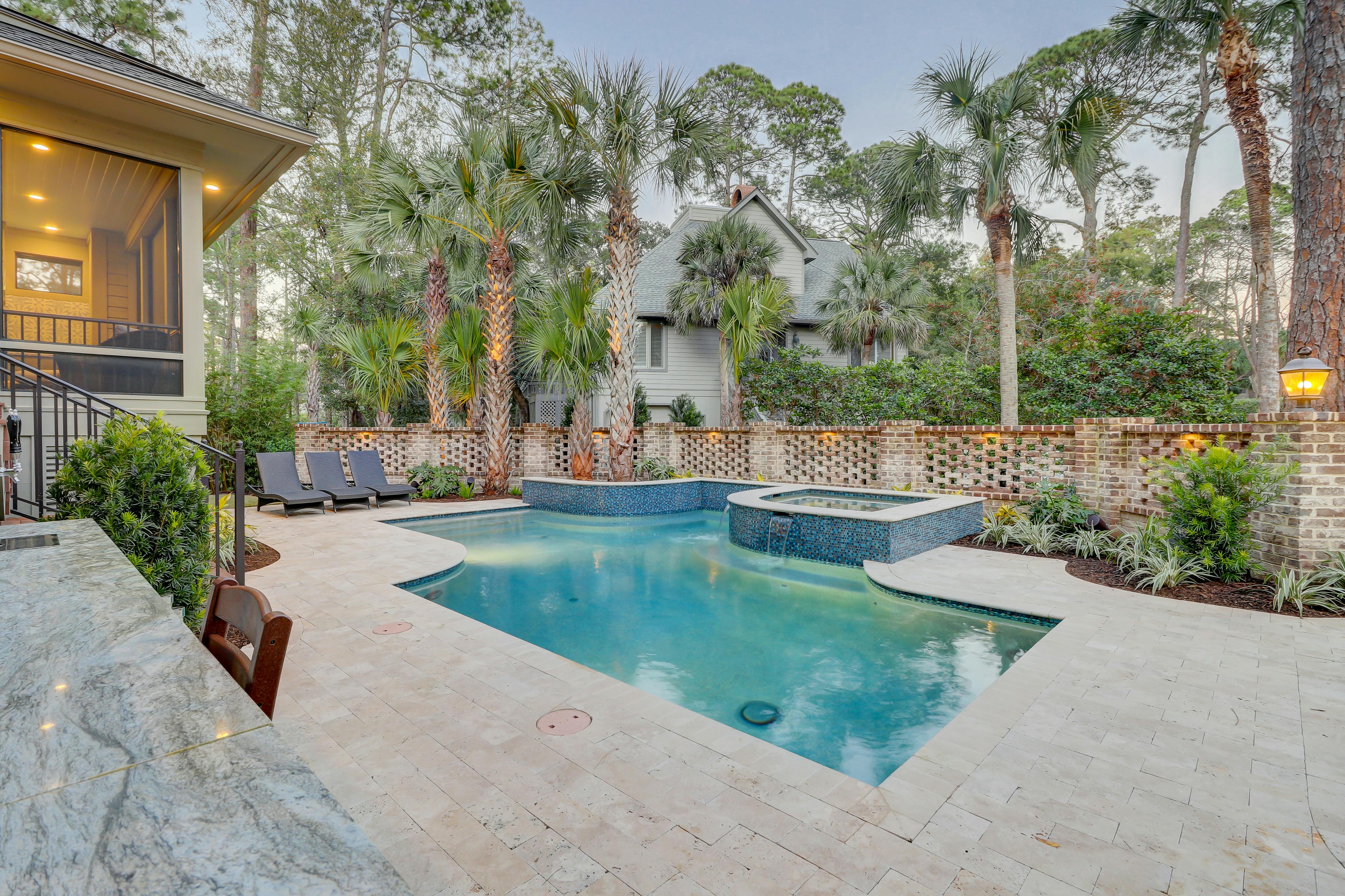 hardscaped backyard with pool surrounded by palm trees in hilton head, sc