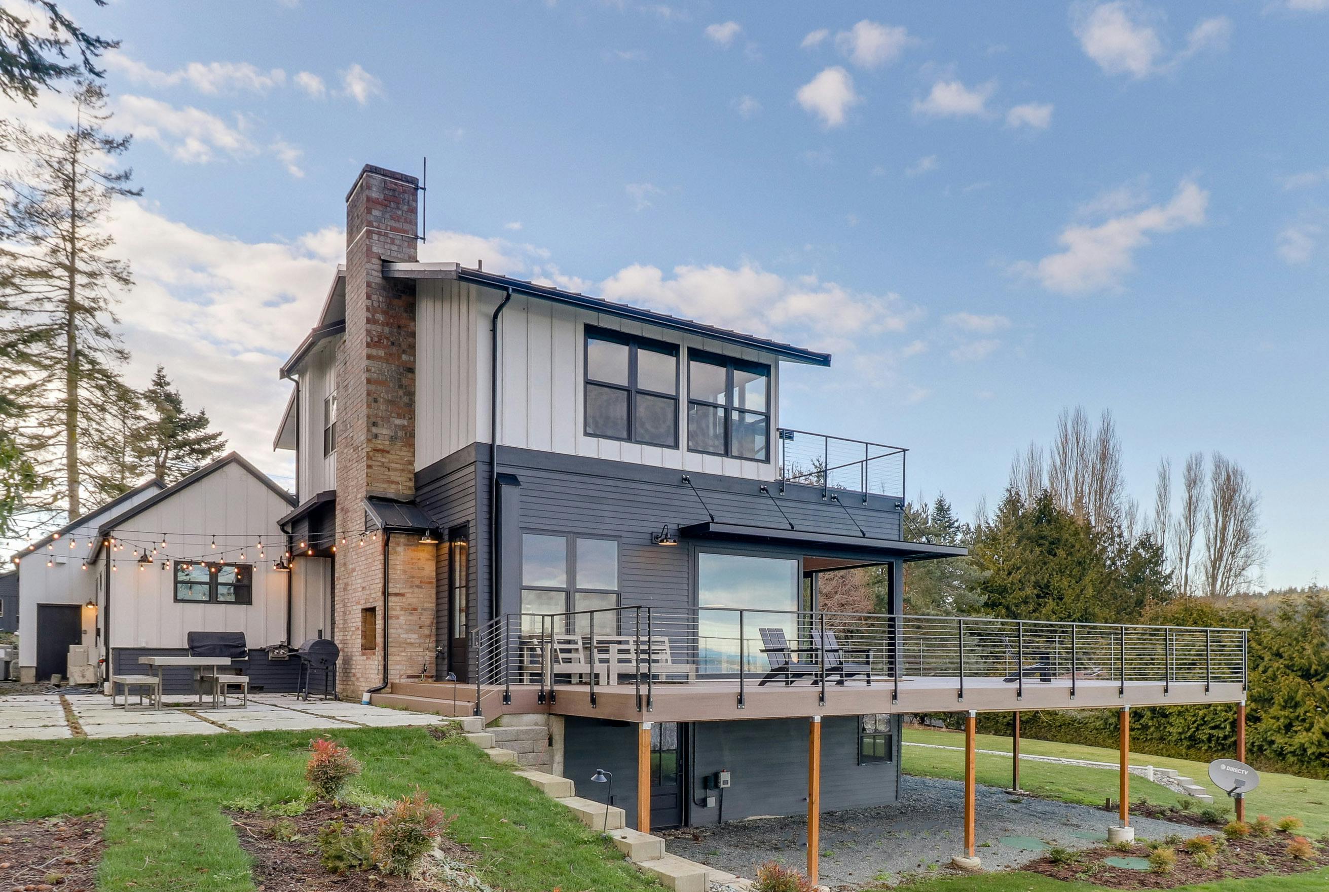 Modern farmhouse with outdoor lights and a large deck on Whidbey Island