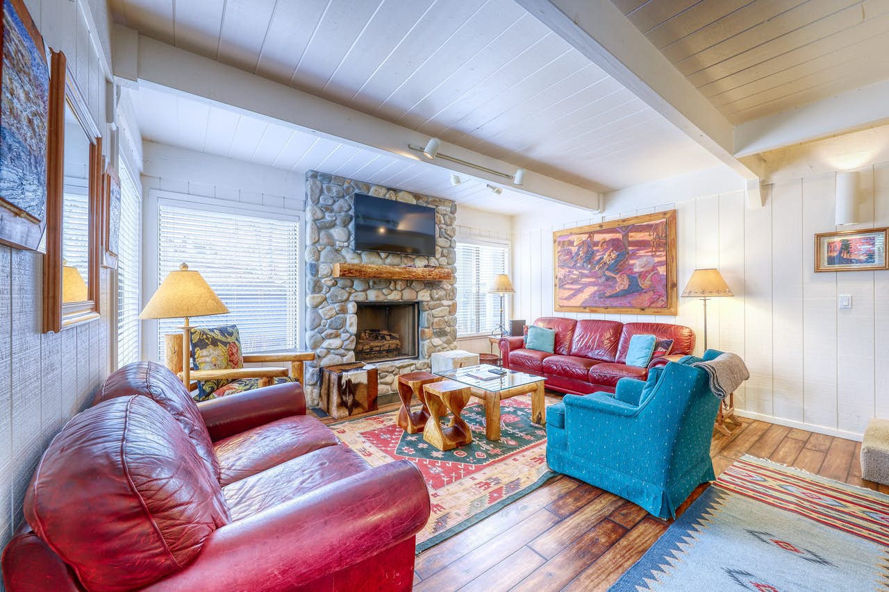 stone fireplace with colorful couches and decor inside Sun Valley vacation rental