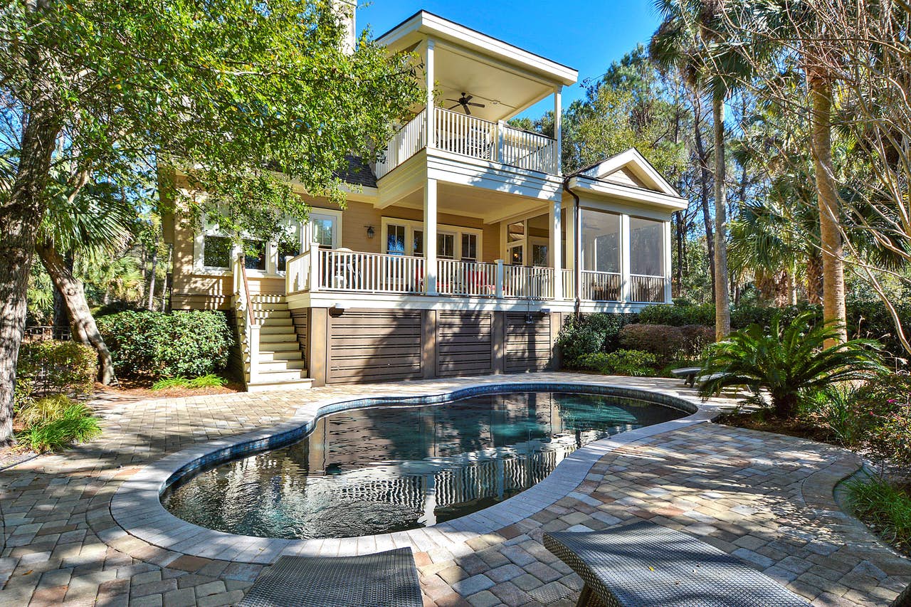 Multi-family style vacation home rental in Kiawah Island, SC with outdoor pool and large trees.