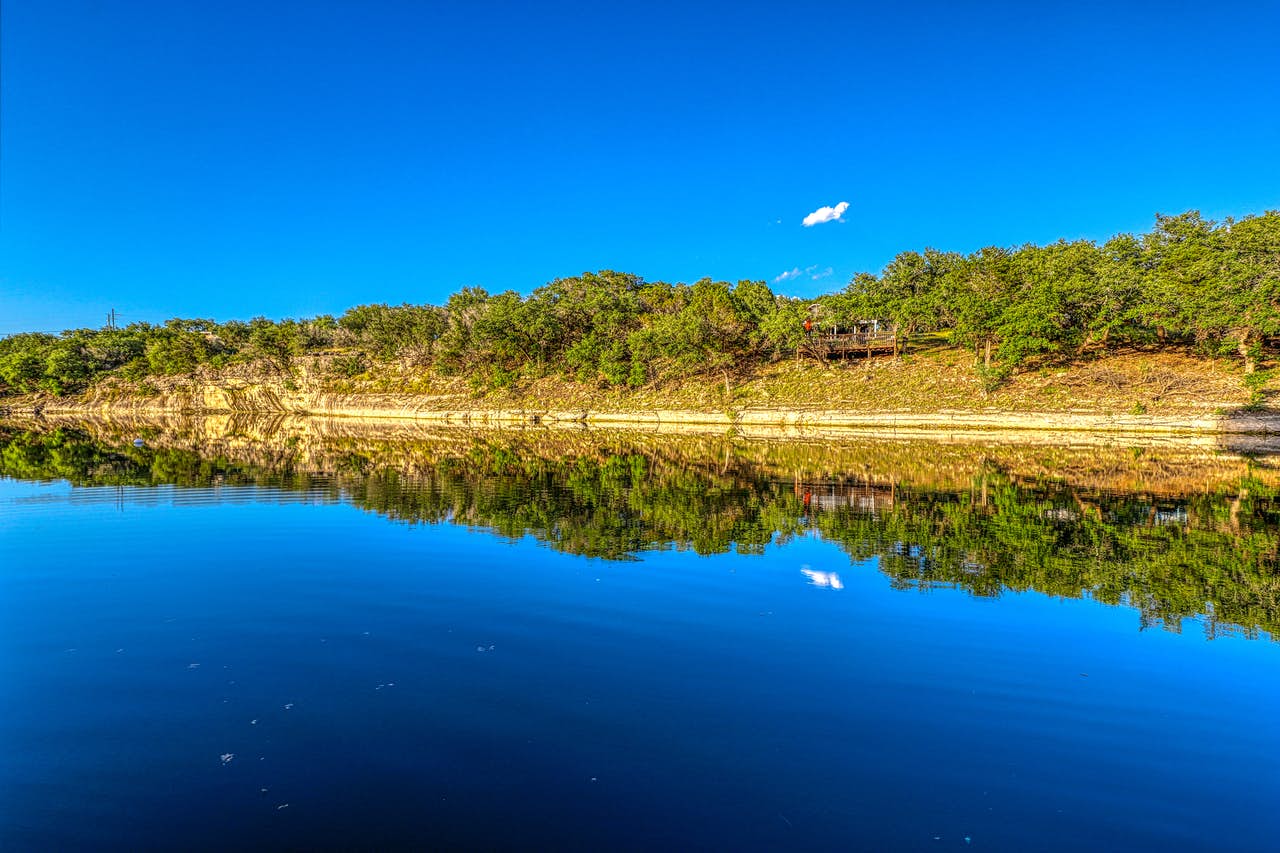 one cloud in blue ski over lake travis