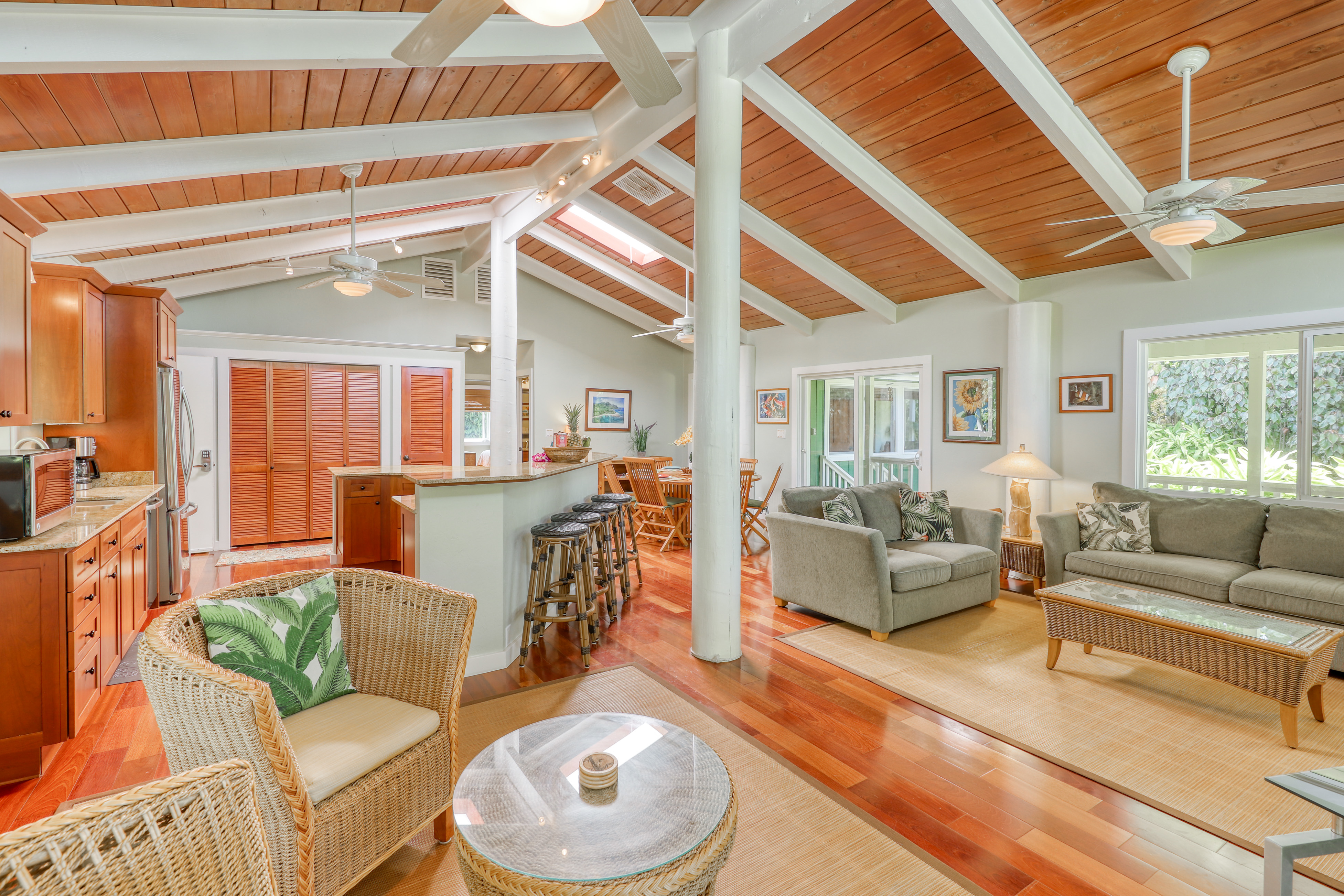 interior of kauai vacation home with countertop seating, wicker furniture and high ceilings