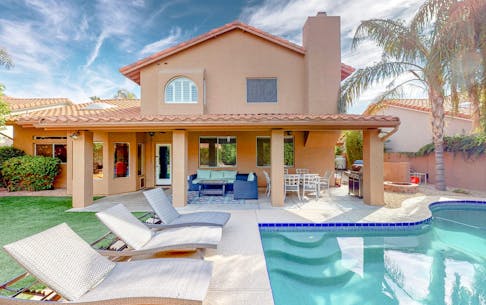 An outdoor pool at a vacation home rental in Phoenix, AZ with pool chairs.