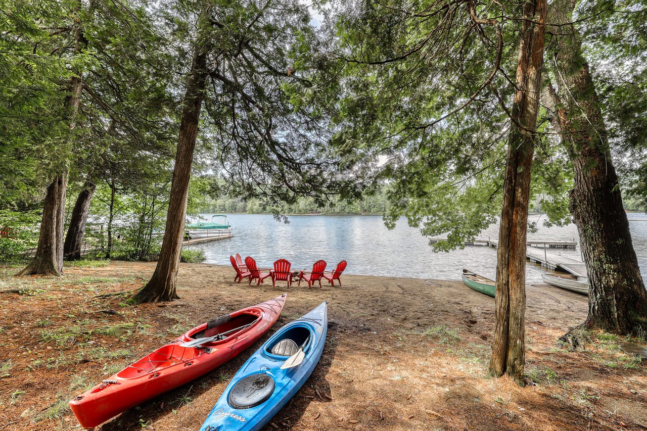 Two kayaks sit near waters edge in The Adirondacks