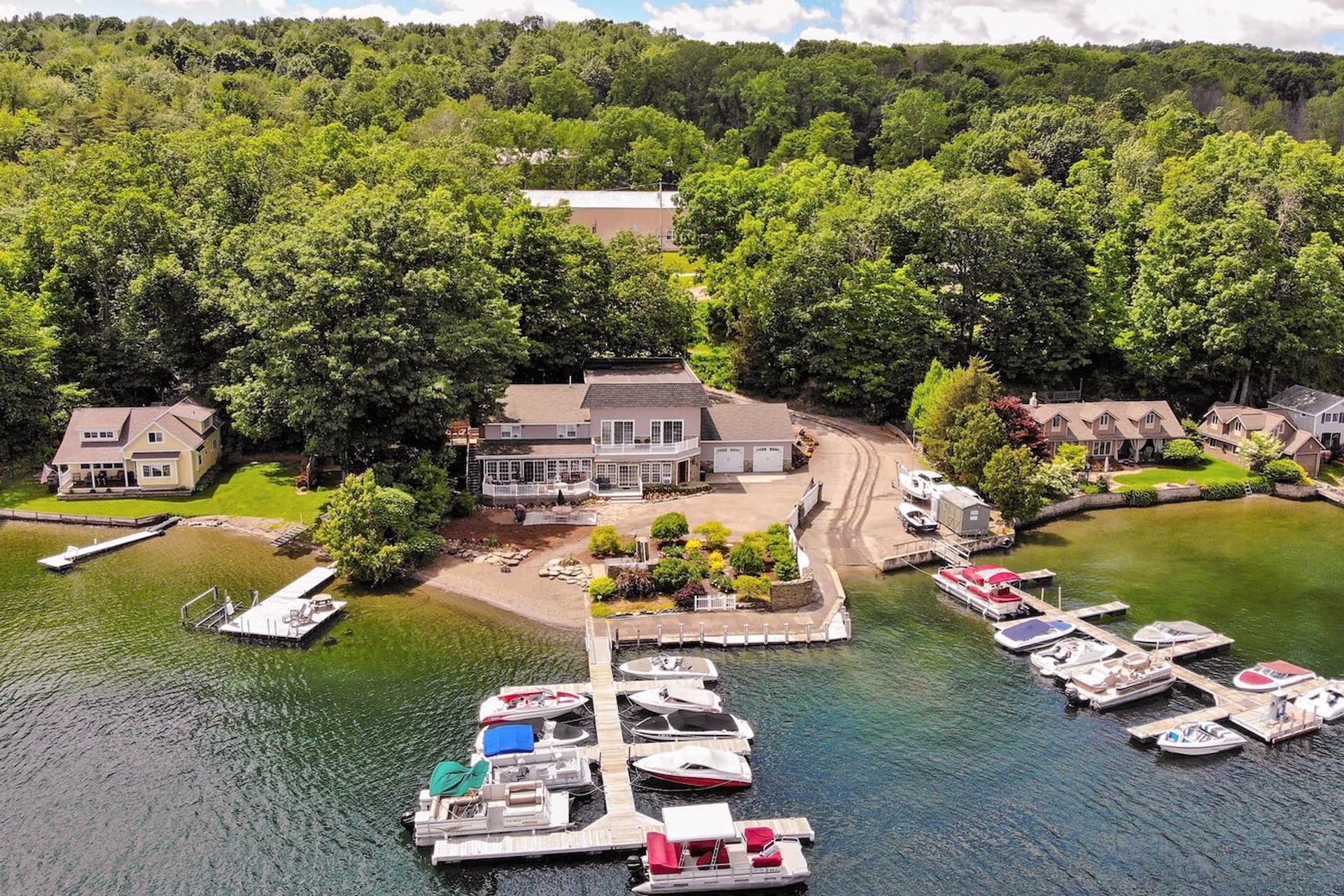 Drone shot of a vacation rental on the lake with a dock surrounded by boats in Penn Yan, NY.