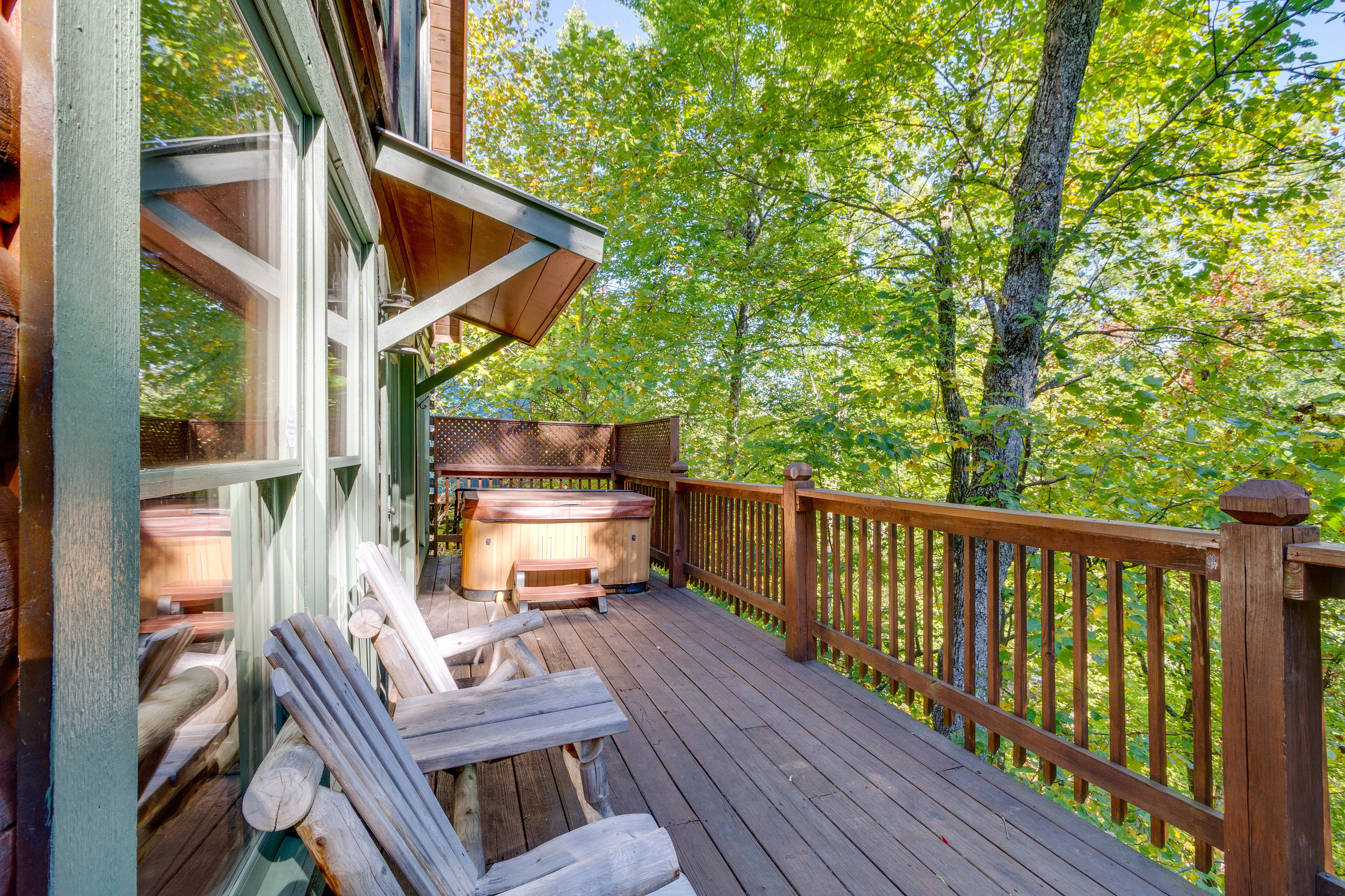 The deck with a hot tub at a pet-friendly rental cabin in Gatlinburg, TN.