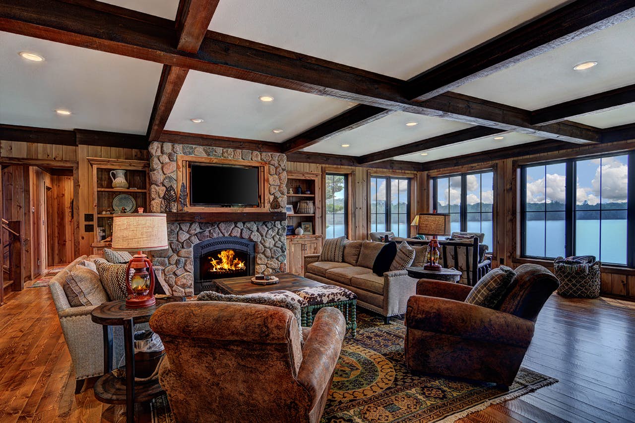 Dark and rustic Sayner, WI living space with large stone fireplace
