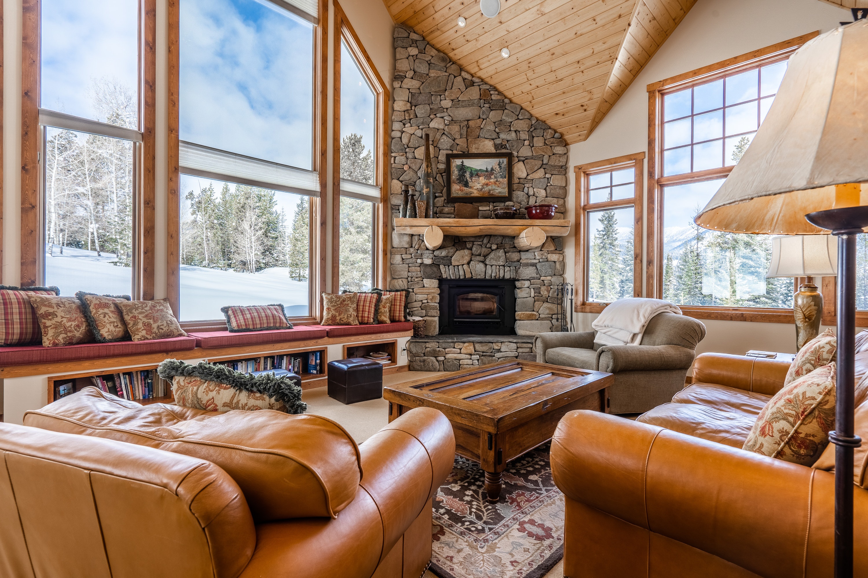 big sky, mt vacation home with large stone fireplace and floor-to-ceiling windows