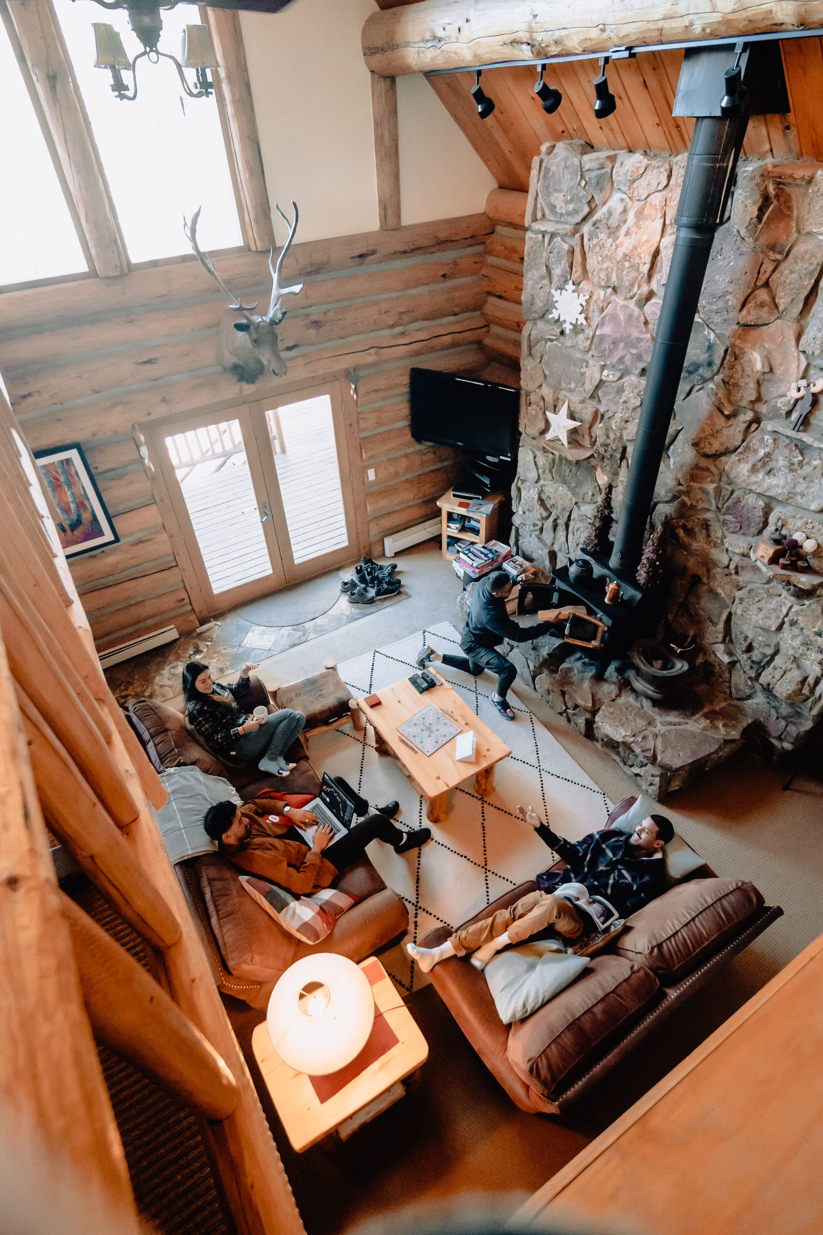group of four friends hang out in living area of vacation cabin