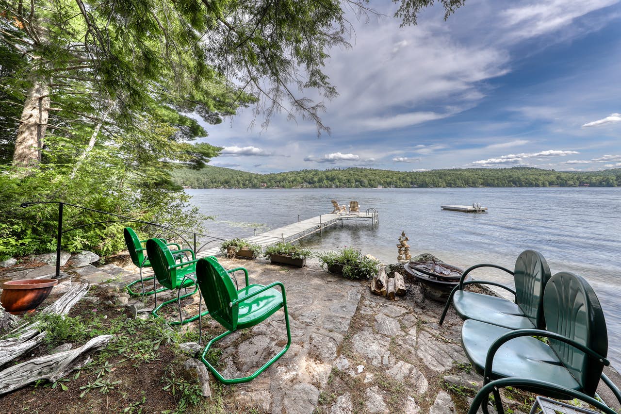 Outdoor chairs overlook boat dock on Brant Lake