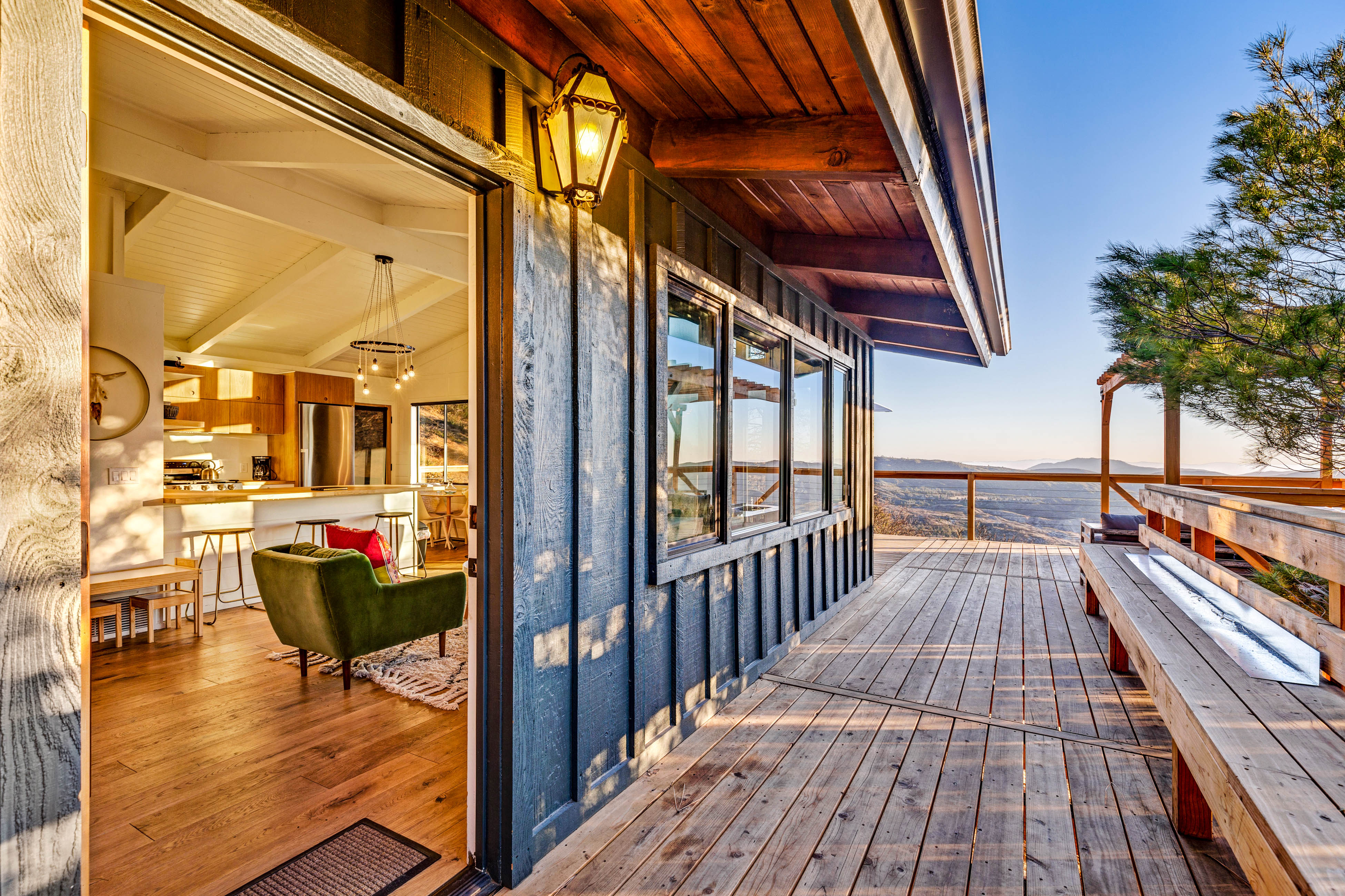 deck with mountain views and open door showcasing modern furnishings inside the home