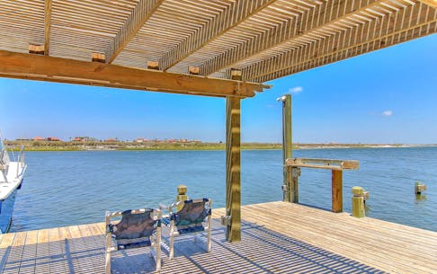 Two folding chairs sit on dock of vacation rental in Corpus Christi