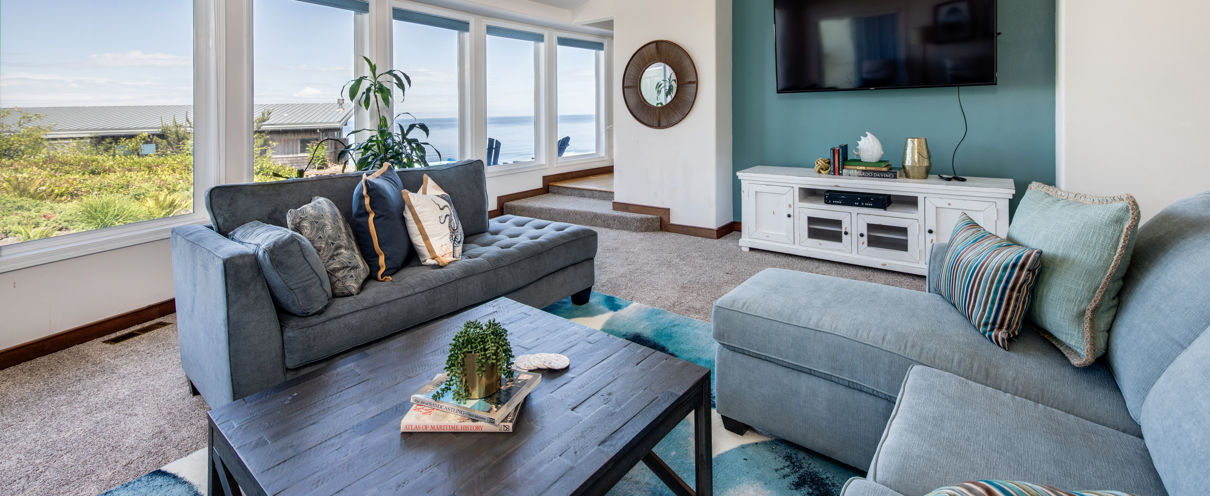 Inside a Neskowin, OR vacation rental with furniture and a view of the ocean during the day.