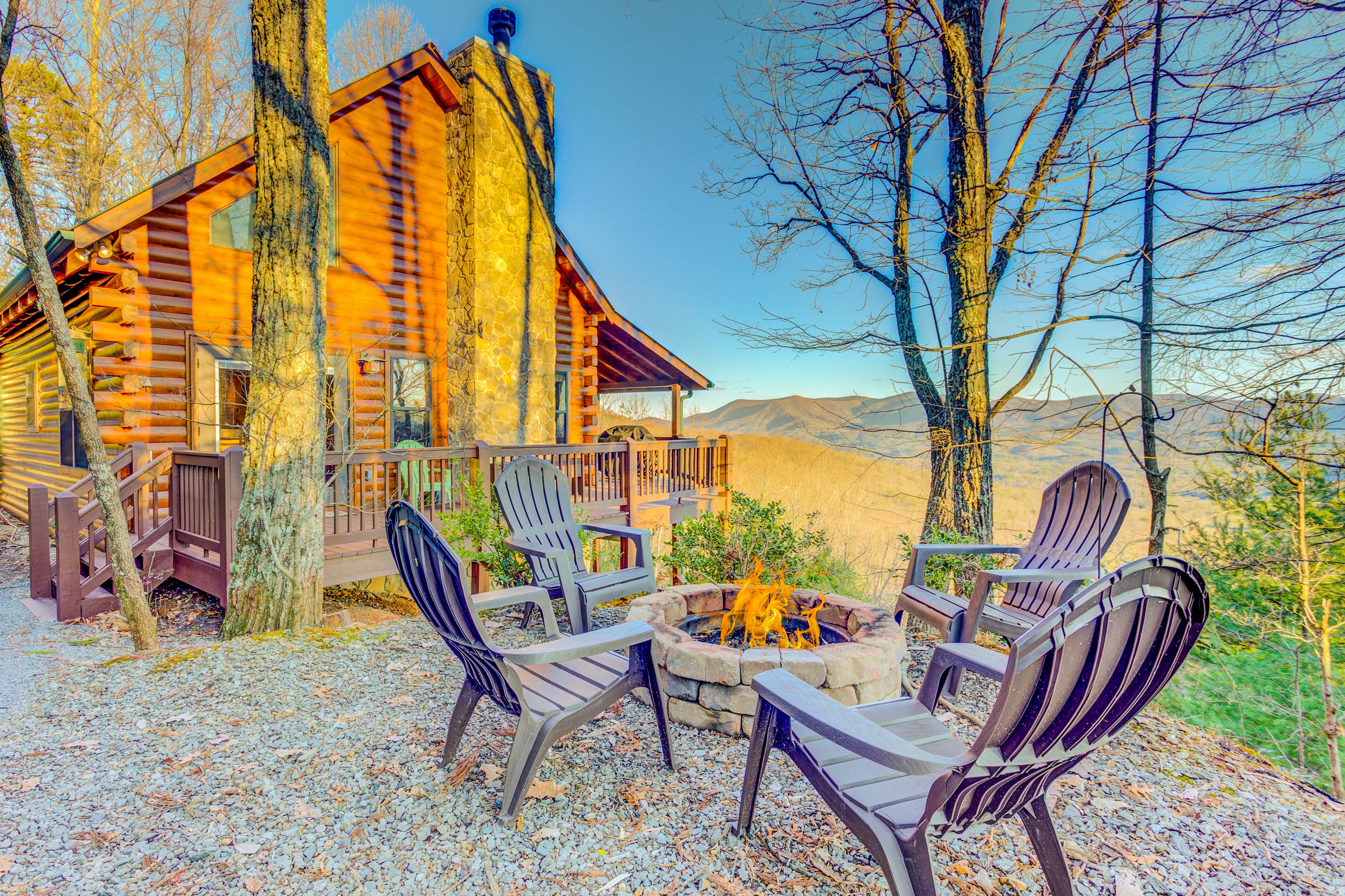 Wood cabin with an outdoor fire pit surrounded by four chairs in Ellijay, GA.