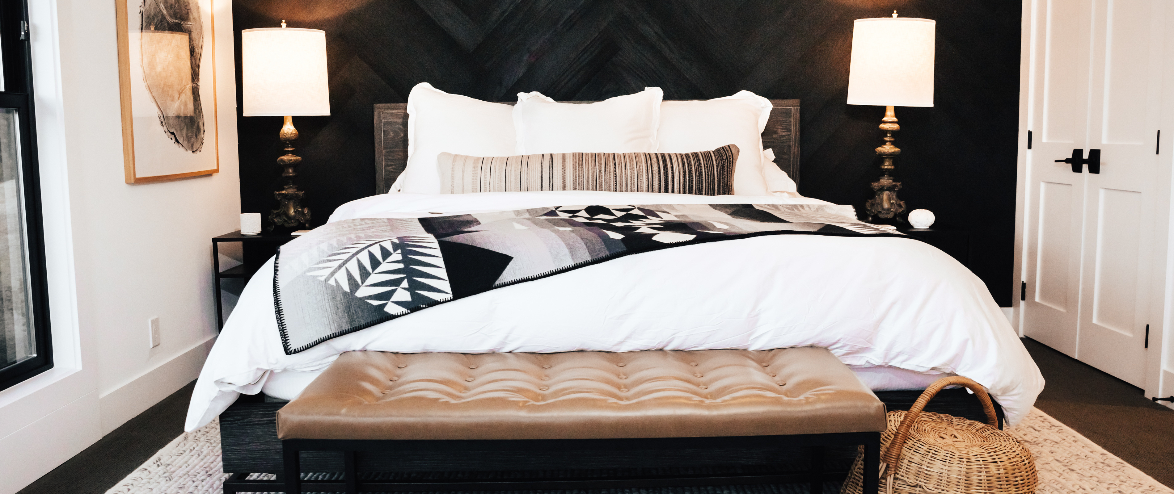 Inside a Whidbey Island vacation rental bedroom with a large white bed and artistic decorations.