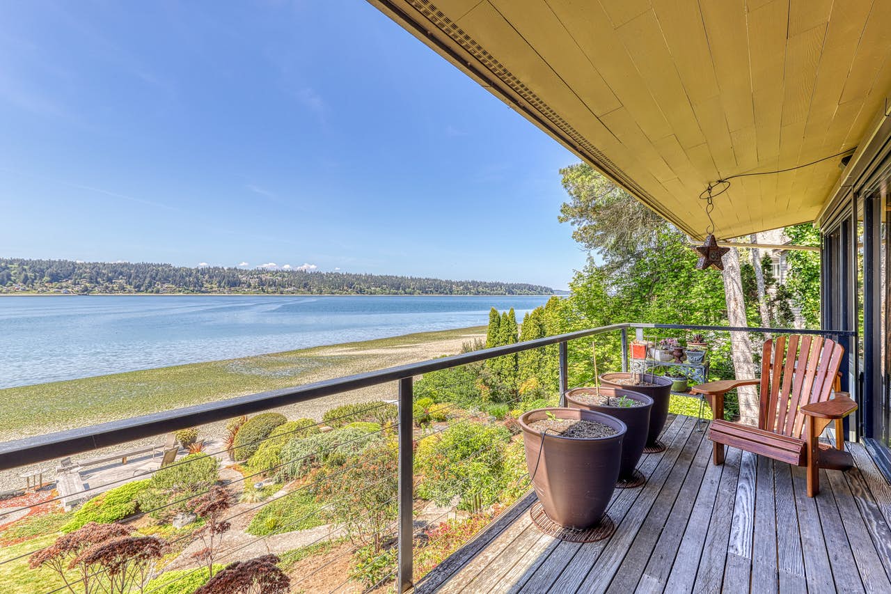 Seattle waterfront vacation rental deck with plants and chairs for relaxing