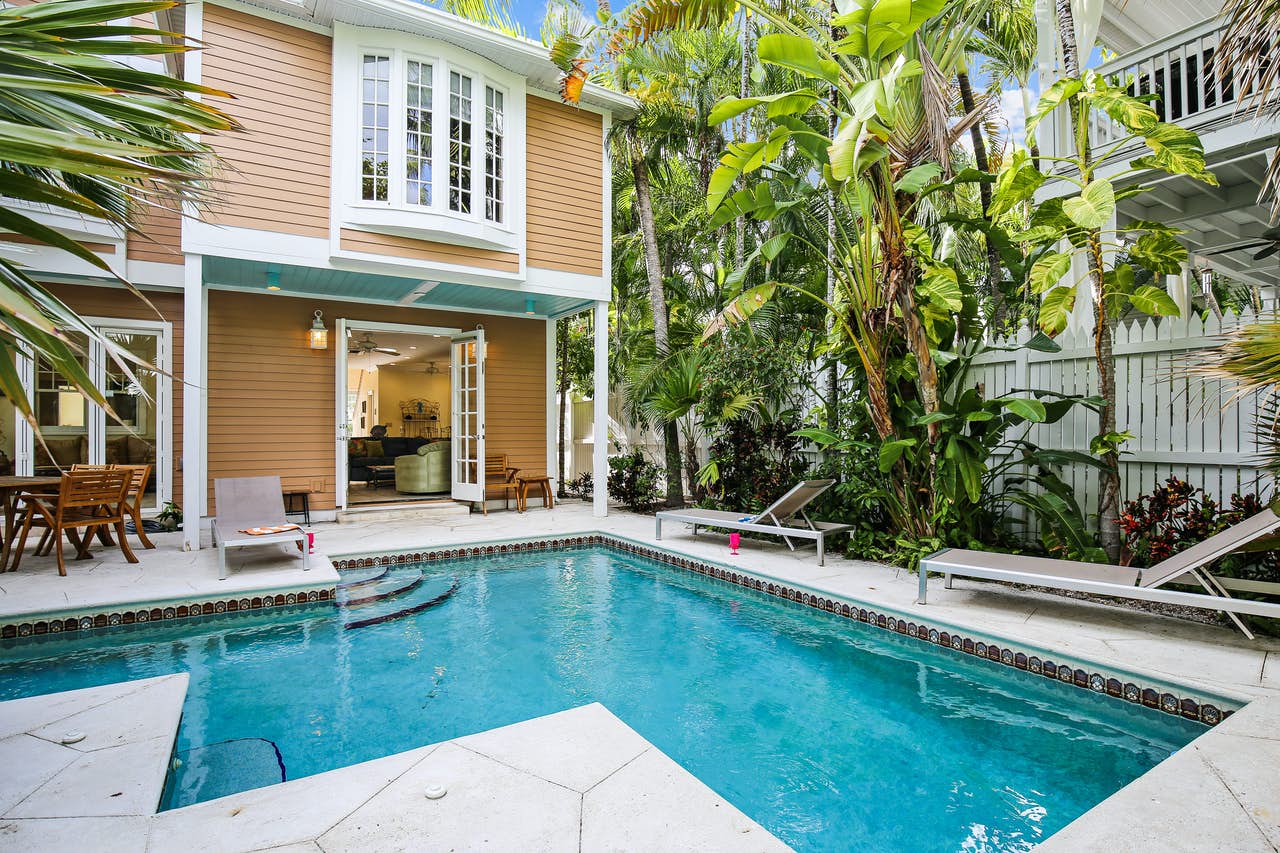Backyard of a vacation home with an outdoor pool and tropical trees in Key West, FL