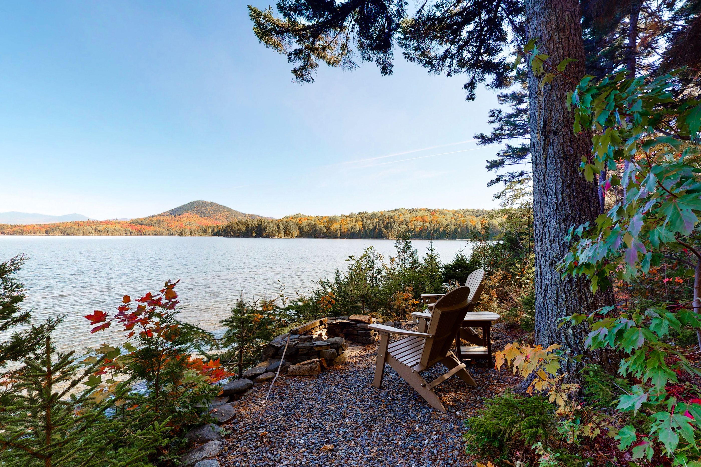 Adirondack chairs perched at the water's edge in Moosehead Lake