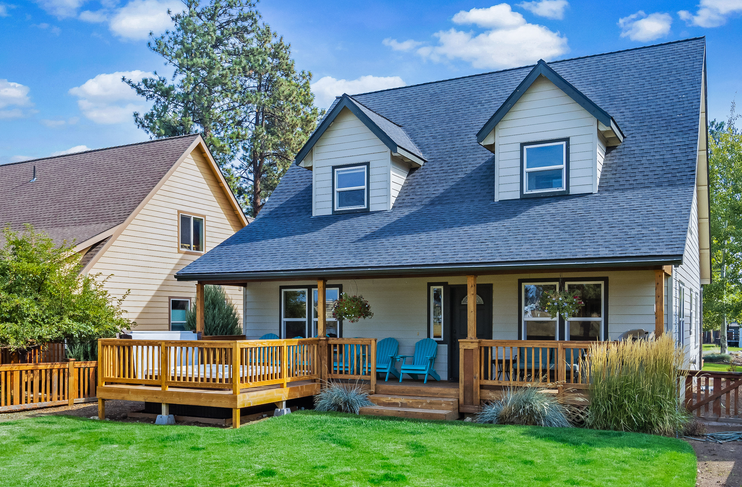 Vacation rental with a hot tub on front porch and green grassy yard