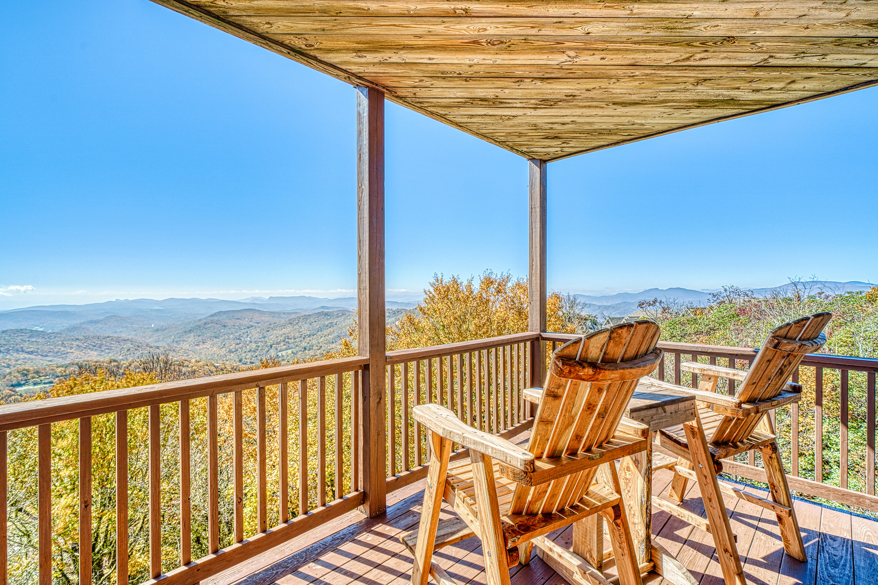 two chairs of cabin overlook the gorgeous blue ridge mountains on a beautiful sunny day