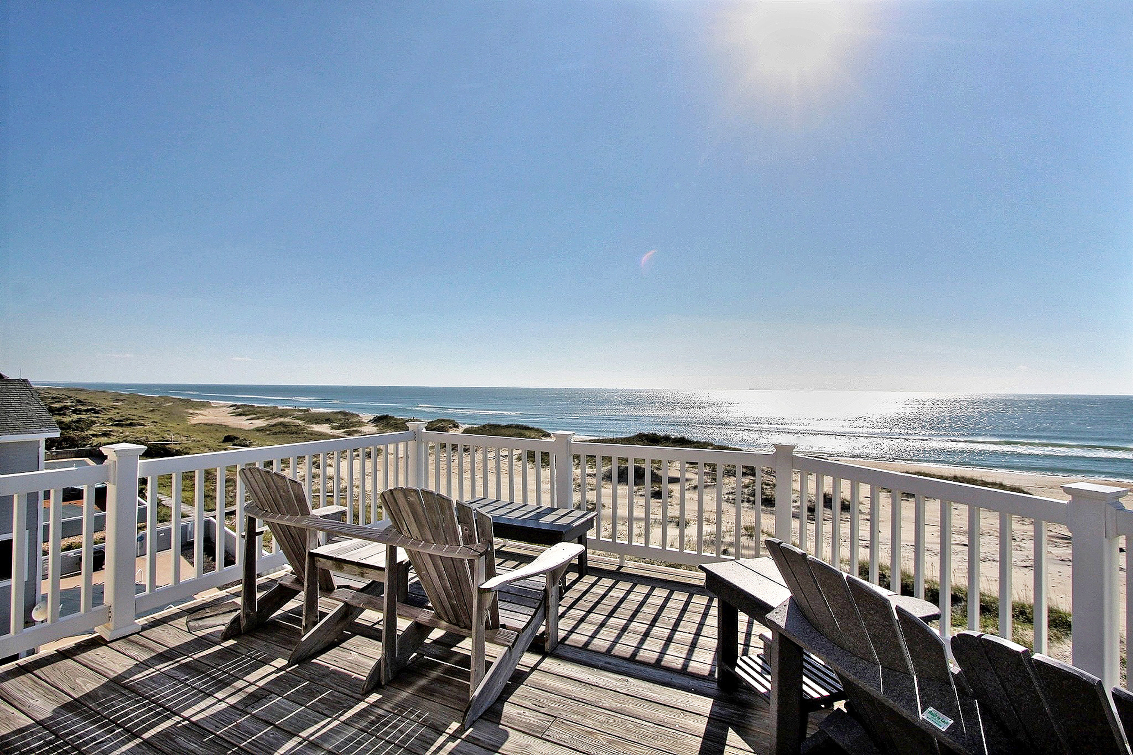 ocean facing deck of outer banks vacation rental with adirondack chairs
