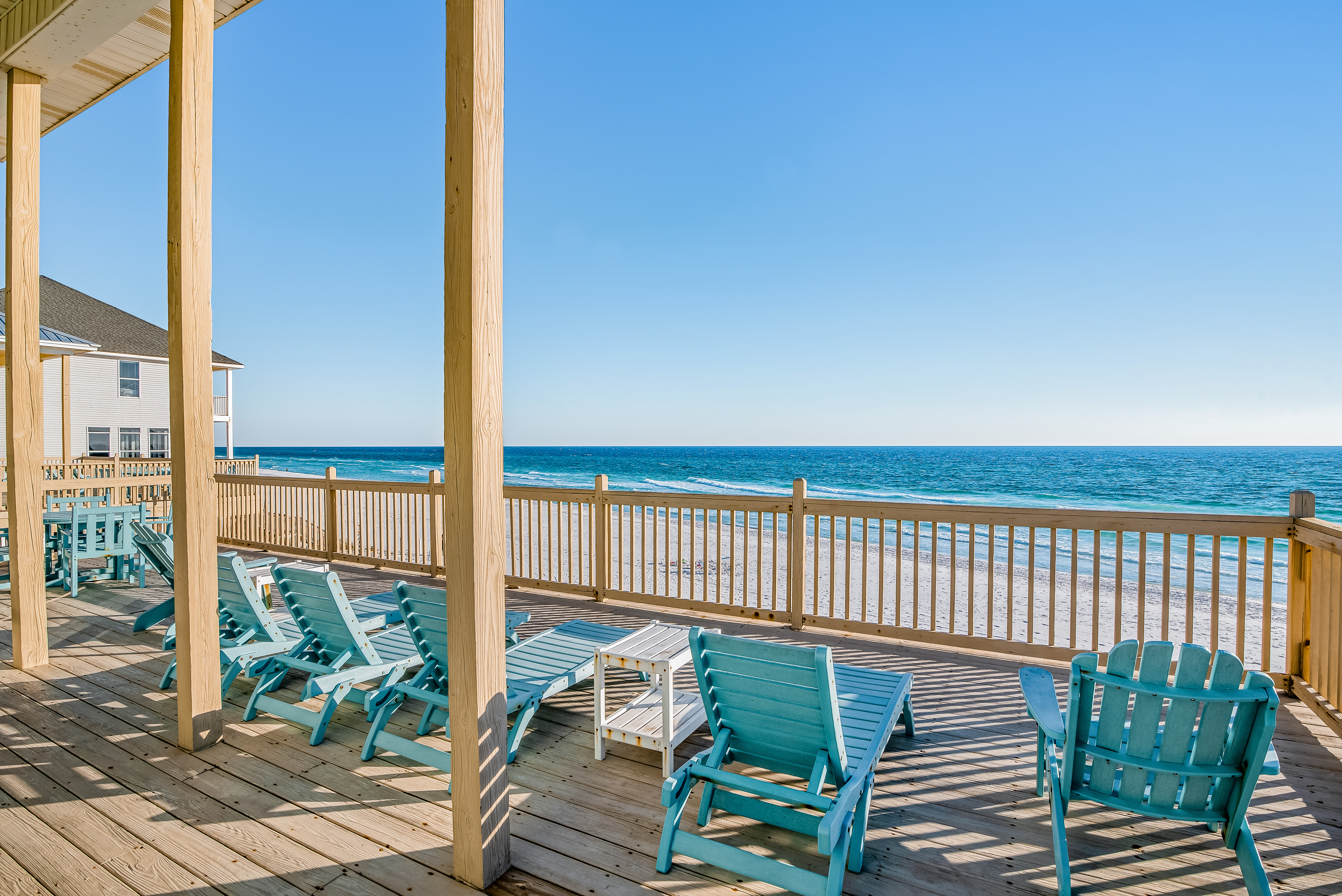 deck of large beachfront home in florida with pretty blue lounge chairs