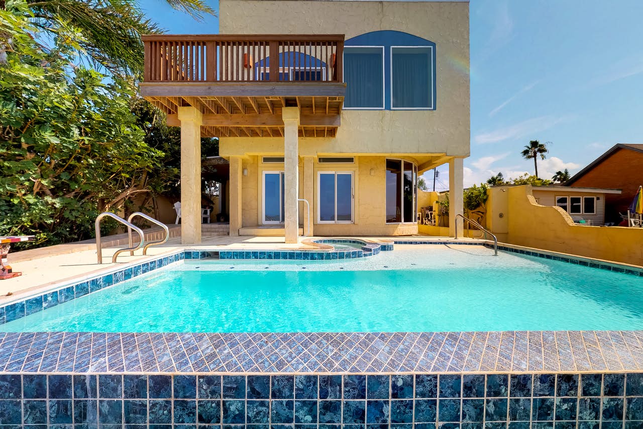 Outdoor pool with clear water at a villa style vacation home rental in Texas Gulf Coast.