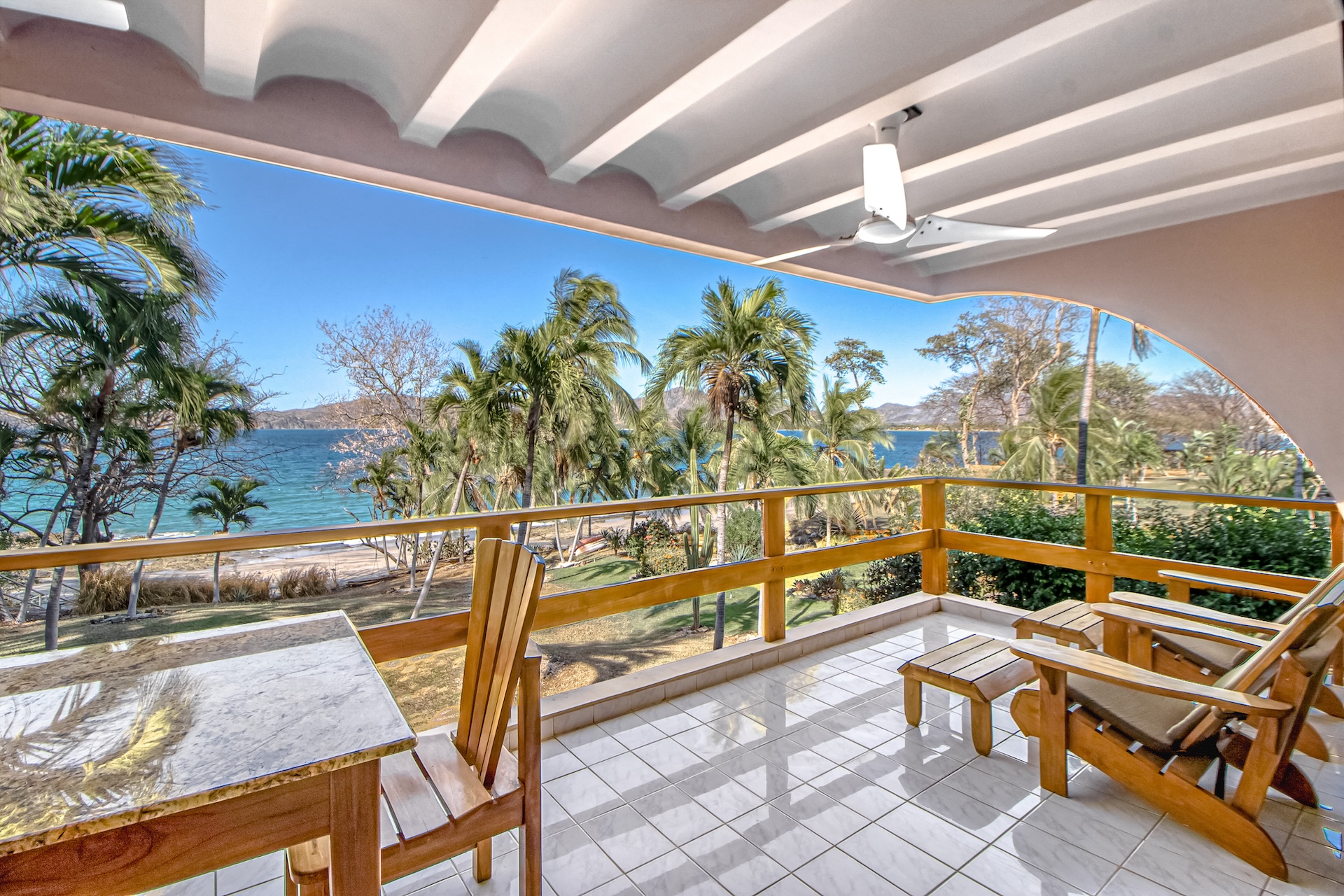 Covered back porch with table and chairs overlooking the ocean.