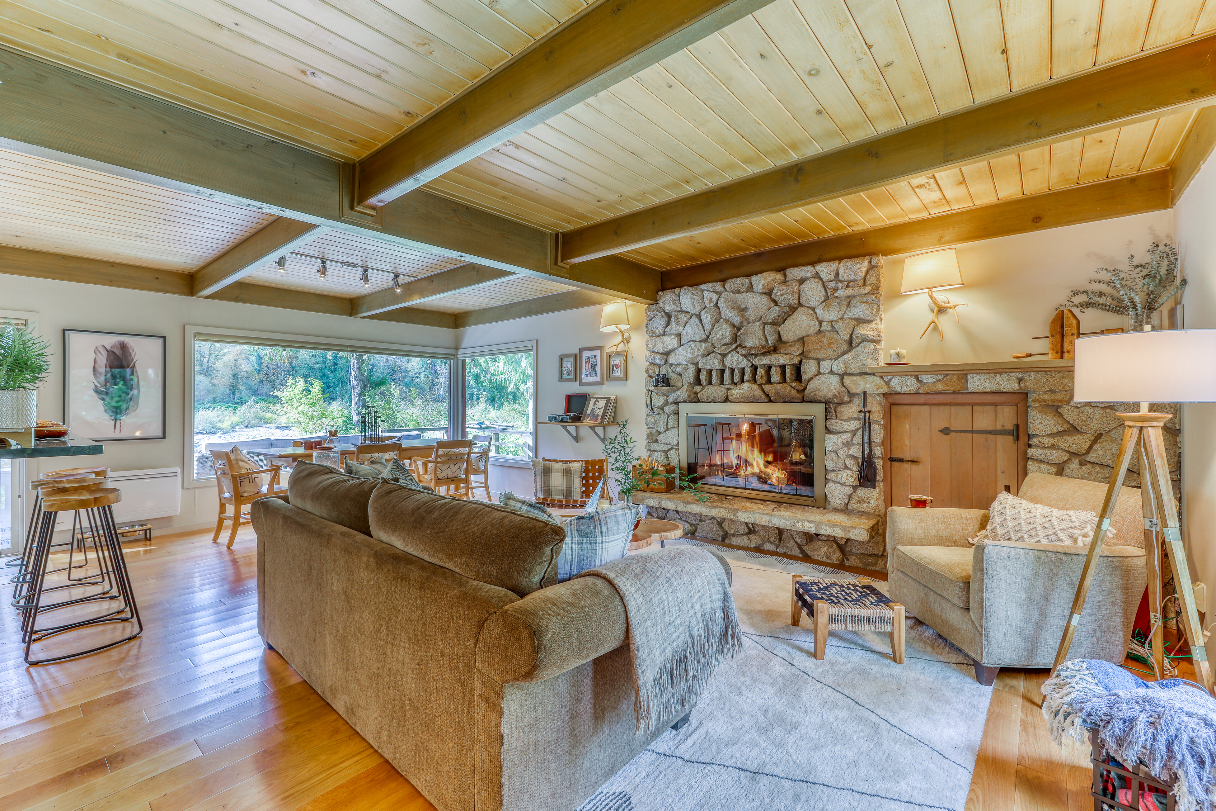 Washington vacation home with stone fireplace, exposed wood beams and a cozy couch