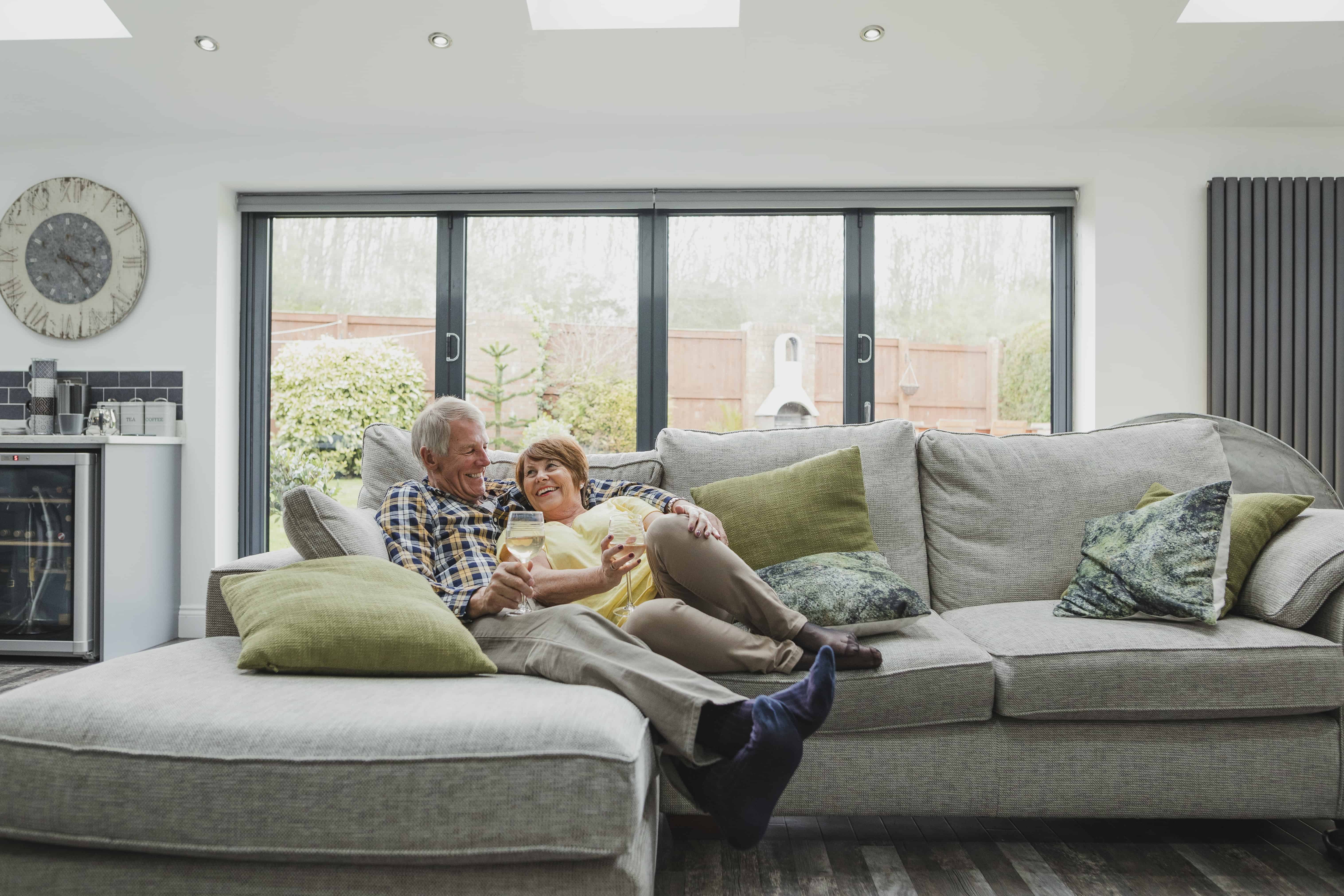A couple on a couch enjoying a glass of wine