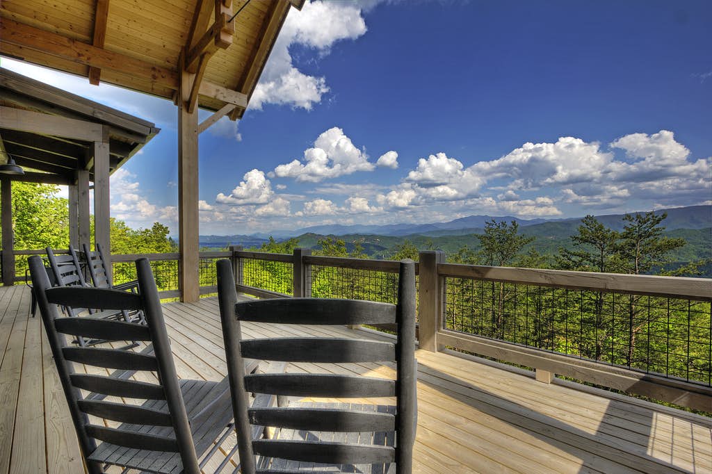 rocking chairs sit on deck overlooking the smoky mountains
