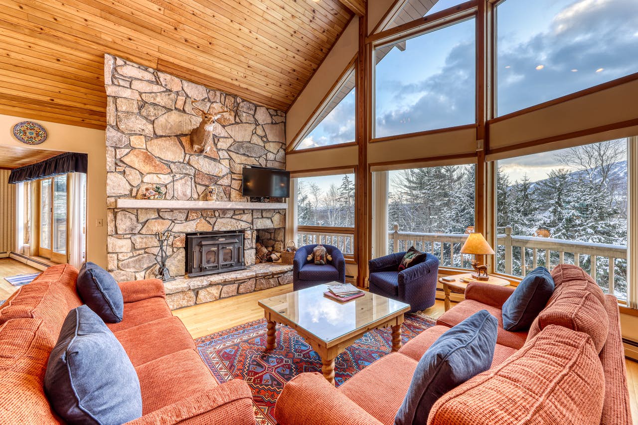 cozy living room with a fireplace and gorgeous views of vermont wilderness
