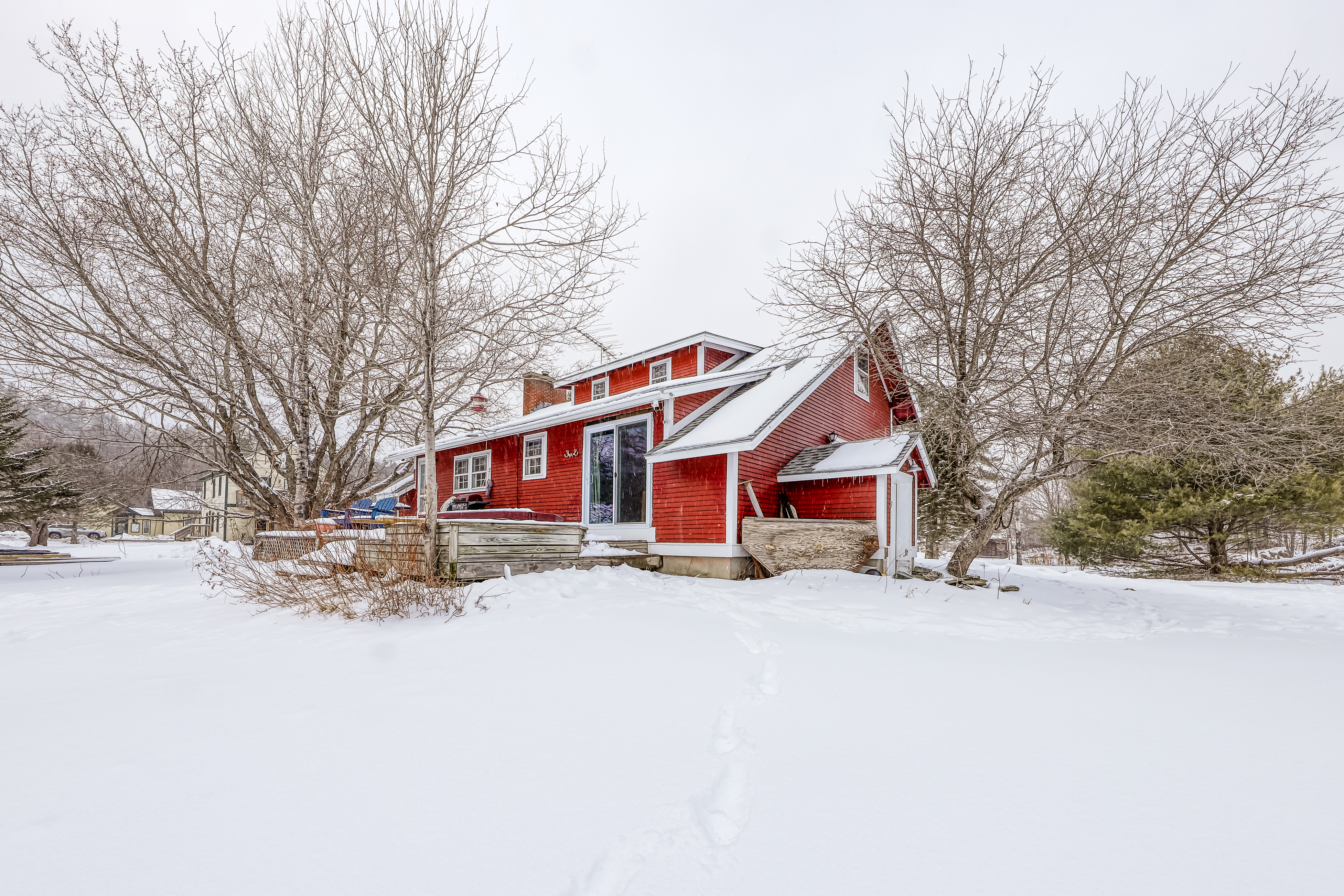 red vacation home surrounded by snow in vermont