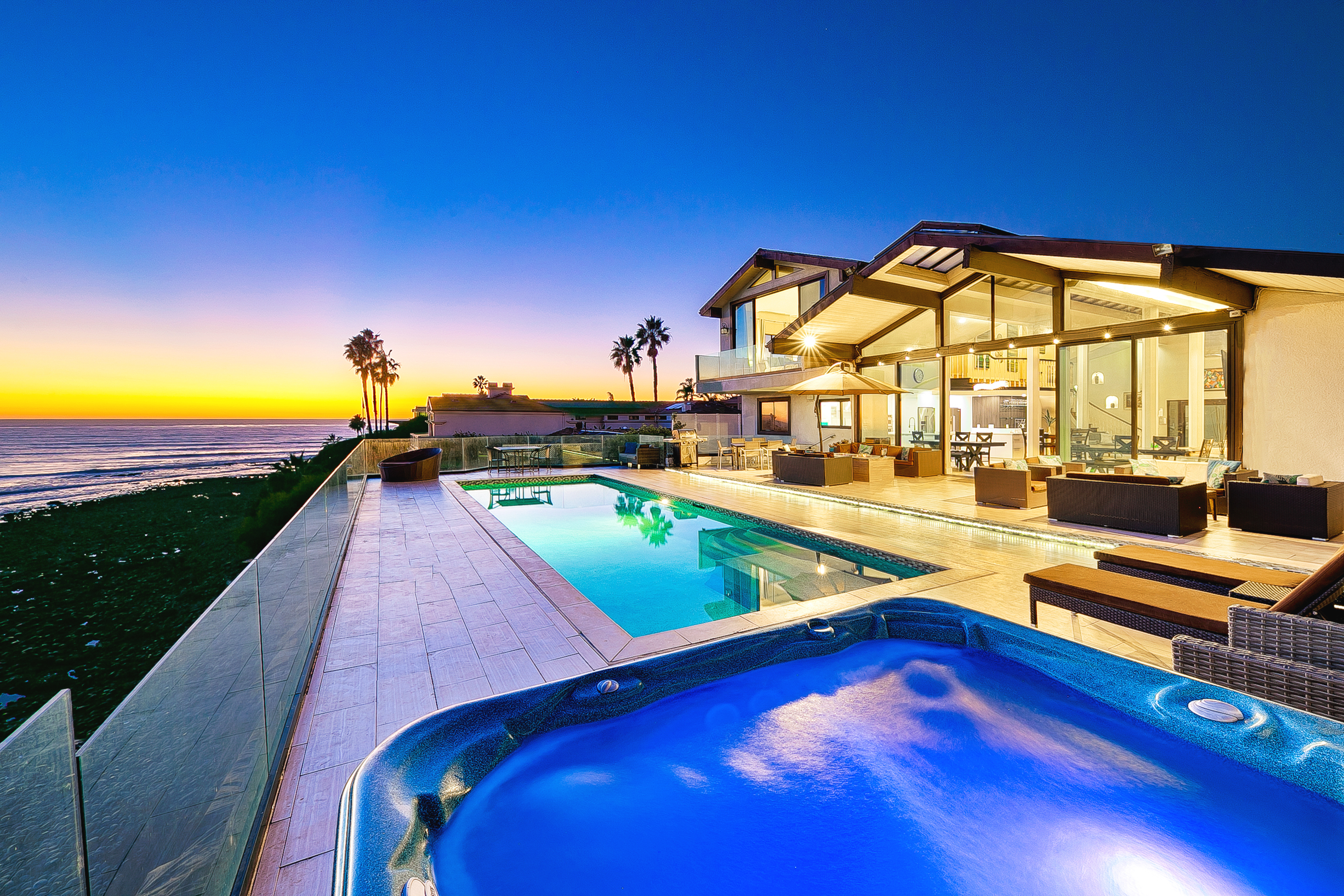 Vacation rental at night with a pool and hot tub by the ocean
