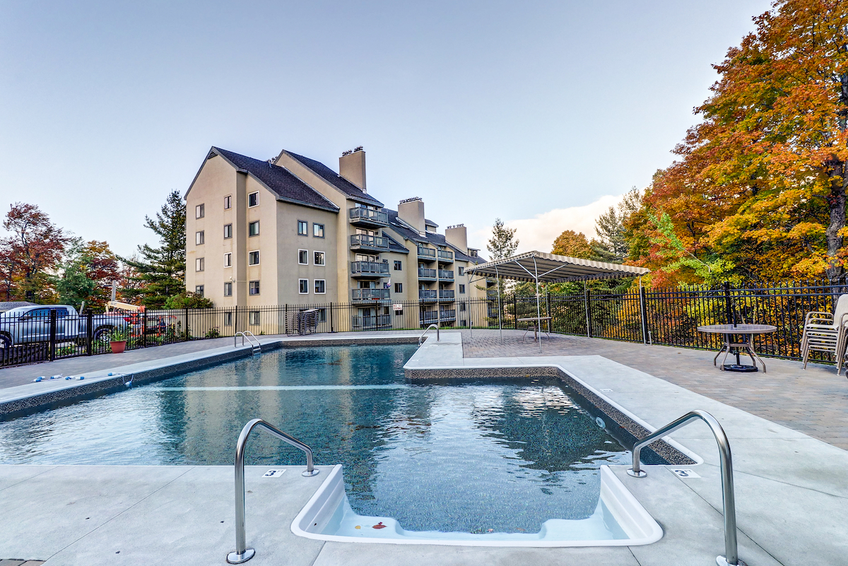 Exterior shot of the Mountain Green resort with a pool in Killington VT.