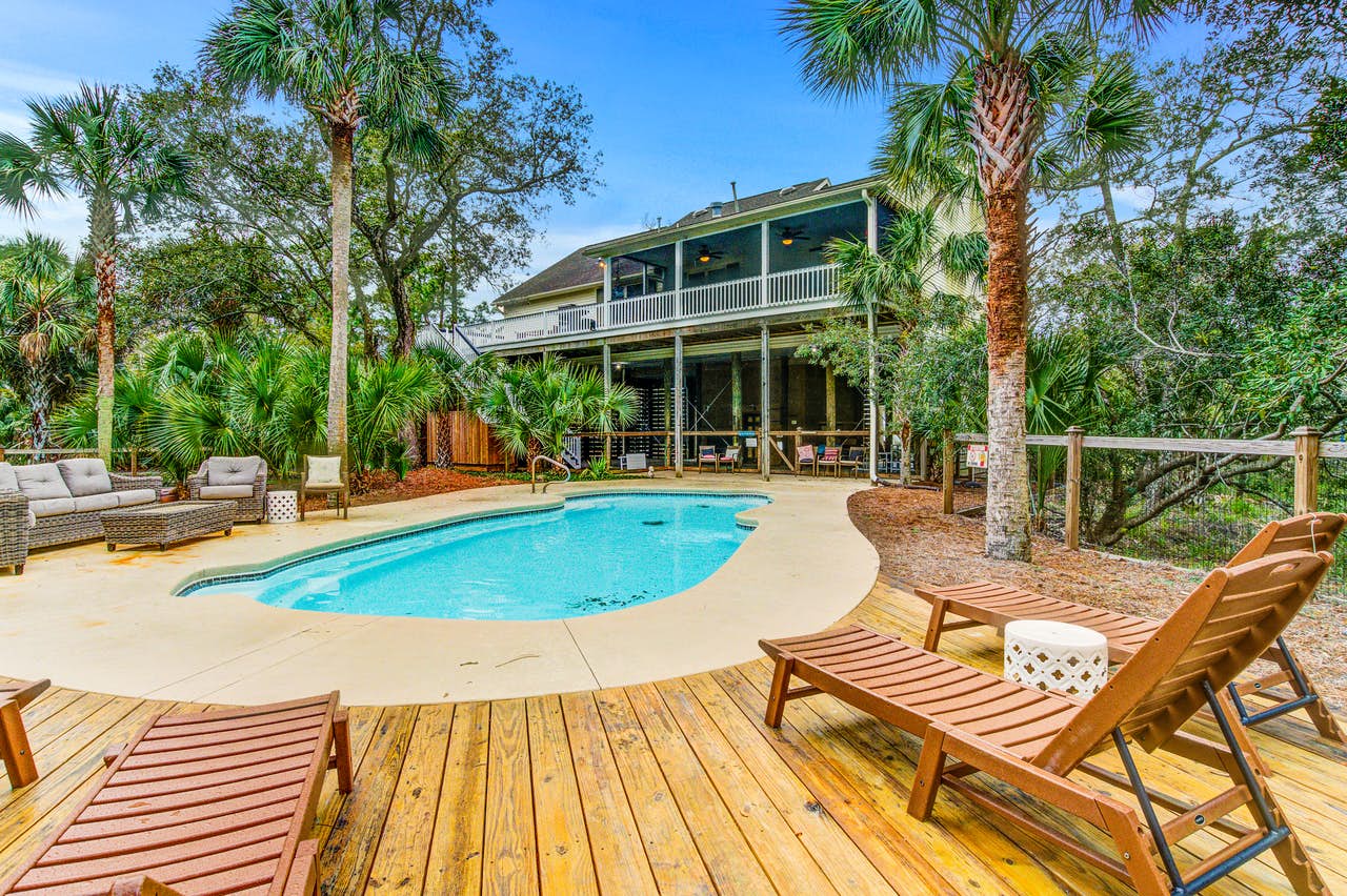 folly beach vacation home with outdoor pool surrounded by palm trees