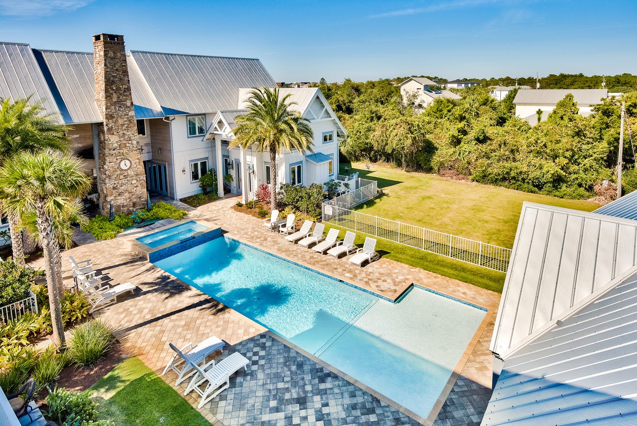 outdoor pool with ample seating of large Miramar Beach, FL vacation rental