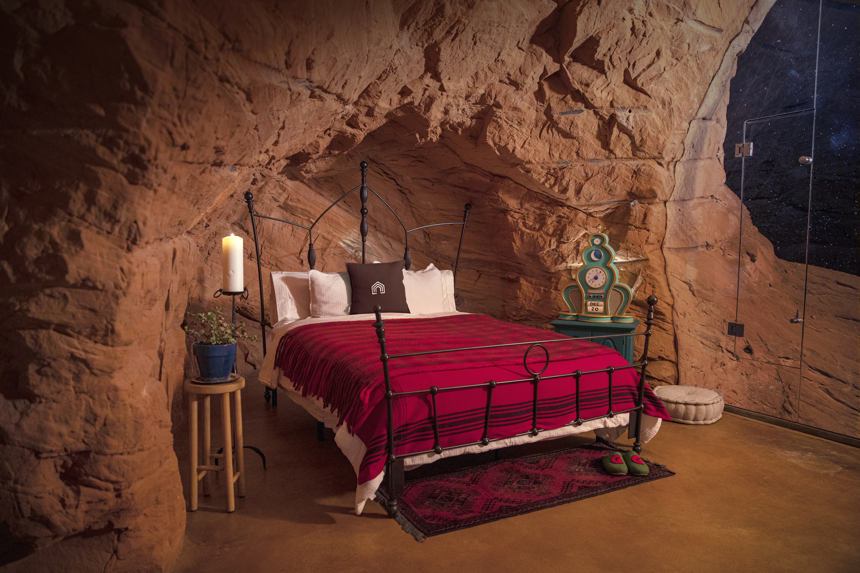 bed with red blanket and black bed frame inside the grinch's cave