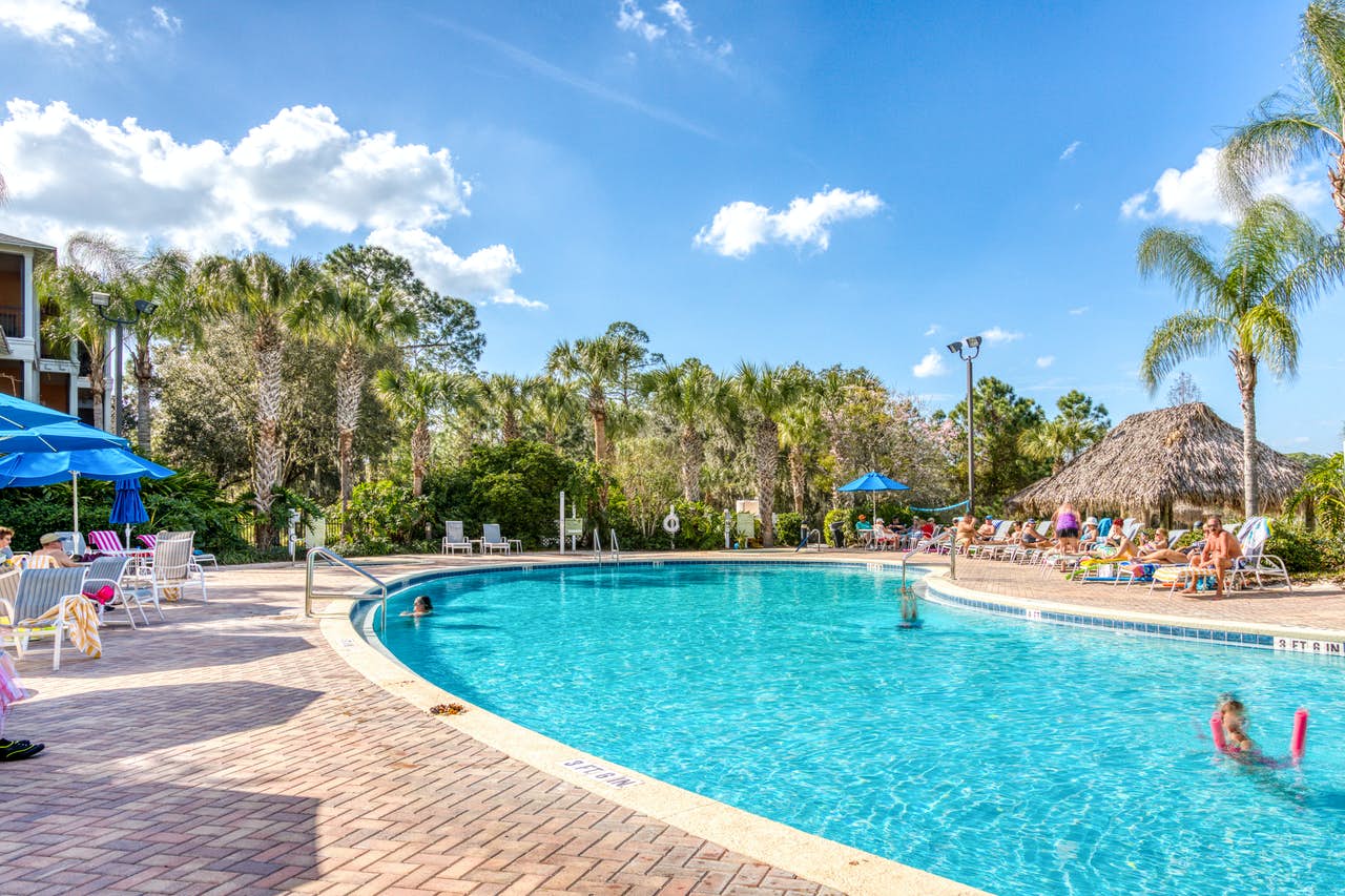 An outdoor pool with families relaxing at a resort in Davenport, FL.