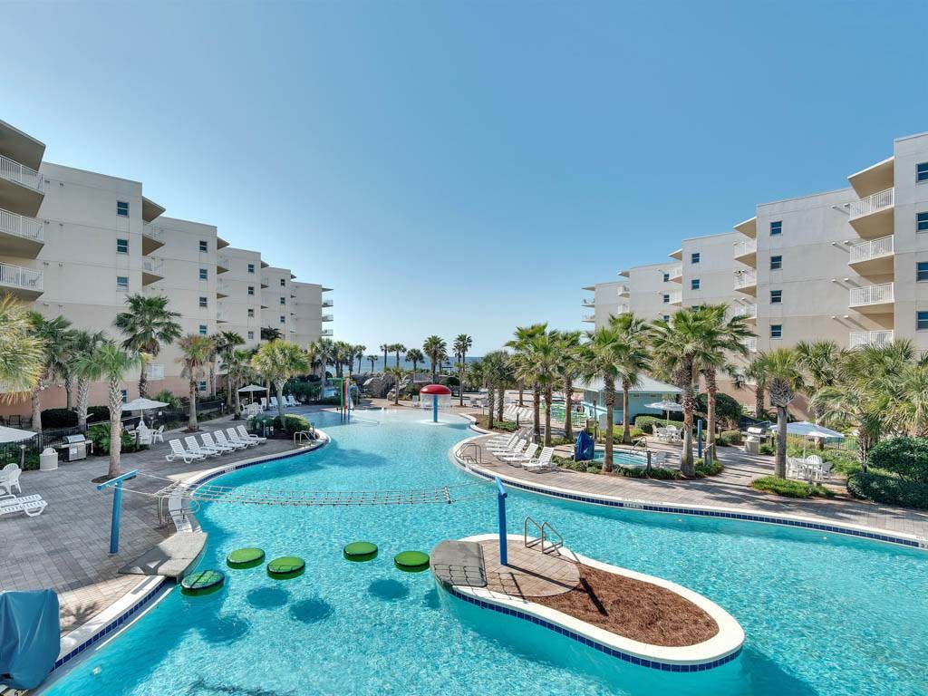 A large outdoor pool at a resort in Fort Walton Beach, FL with an island and pool activities.