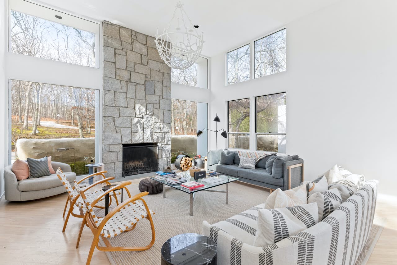 neutral-hued living space with stone fireplace in East Hampton, NY