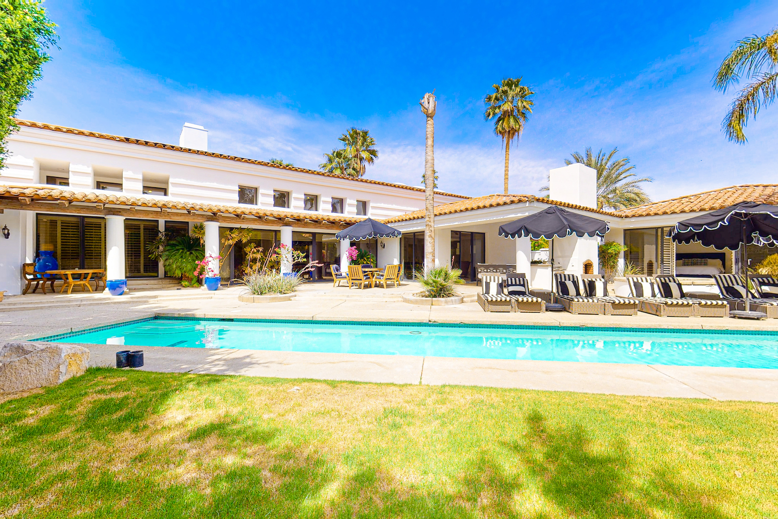 large outdoor pool surrounded by lounge chairs and umbrellas in Palm Springs