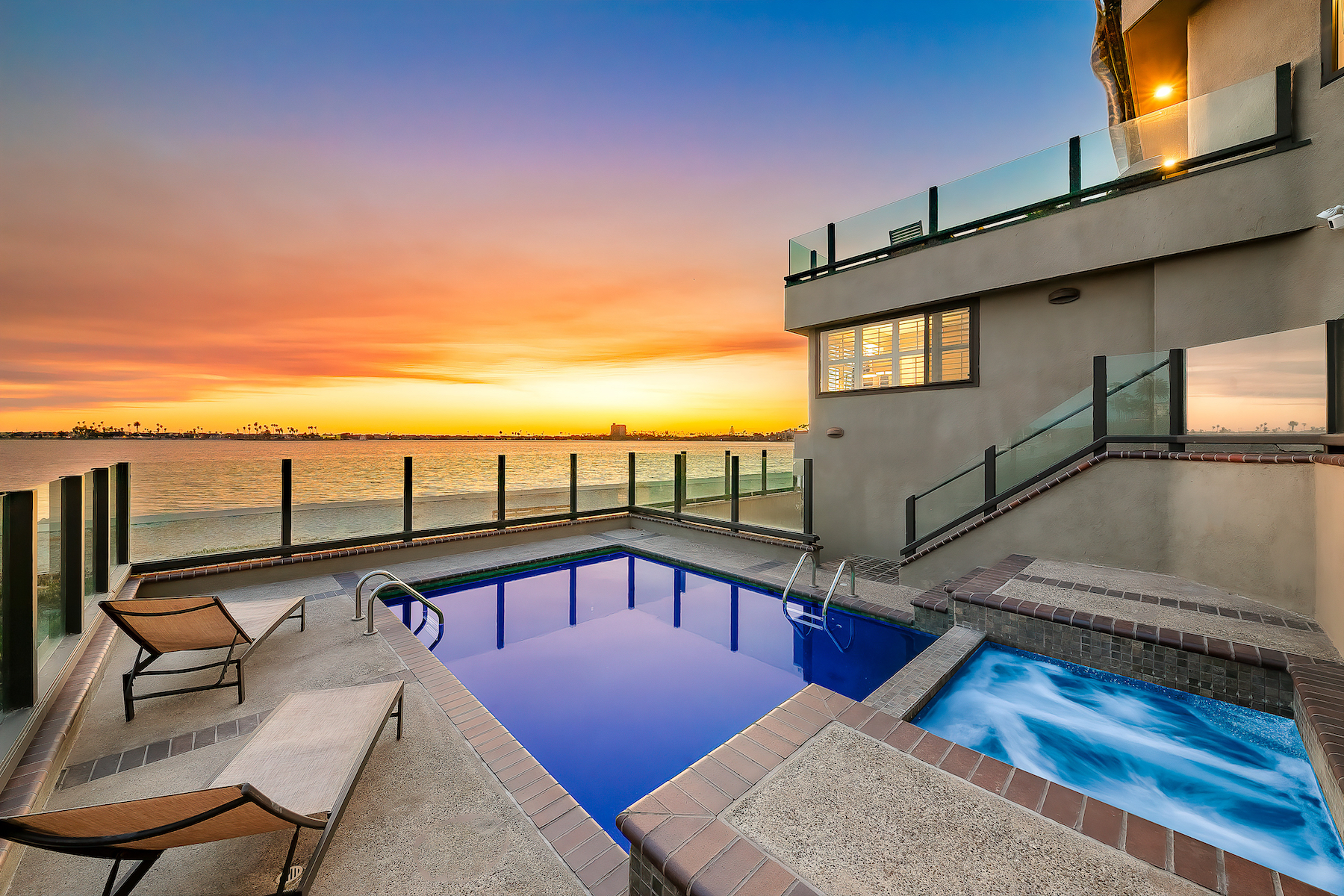 The deck of a beach vacation home in San Diego with a pool and private hot tub.
