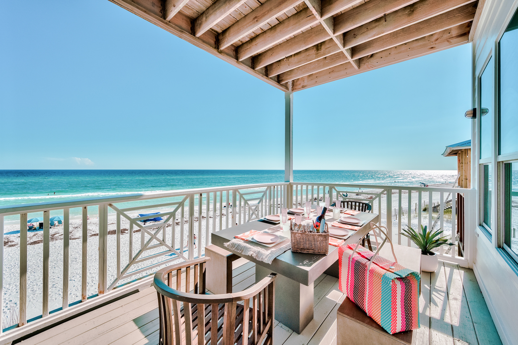 The backdeck with tables and chairs overlooking the beach at a coastal vacation rental in Santa Rosa Beach, Fl.
