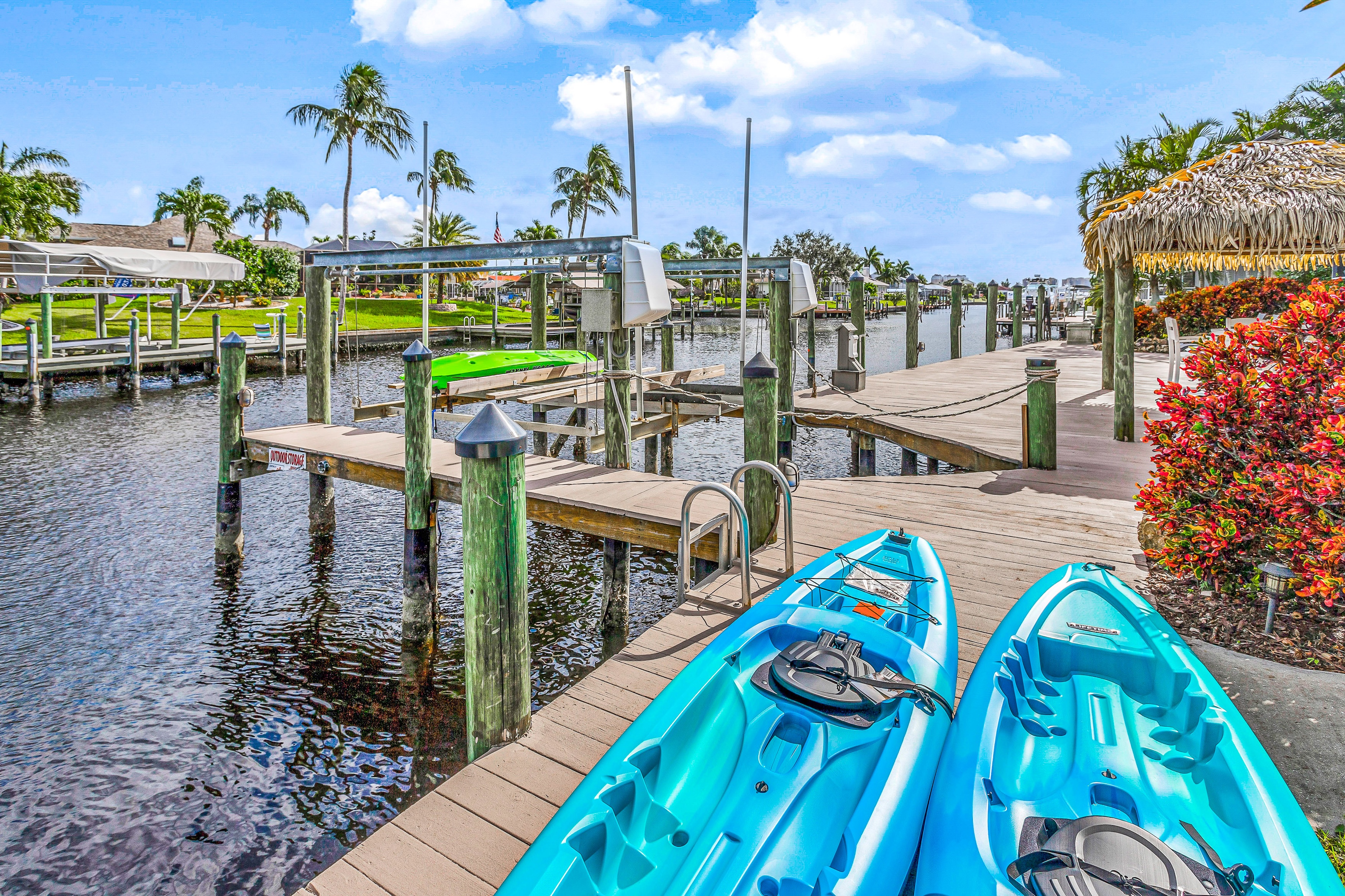 two blue kayaks sit on dock above a slow river in florida