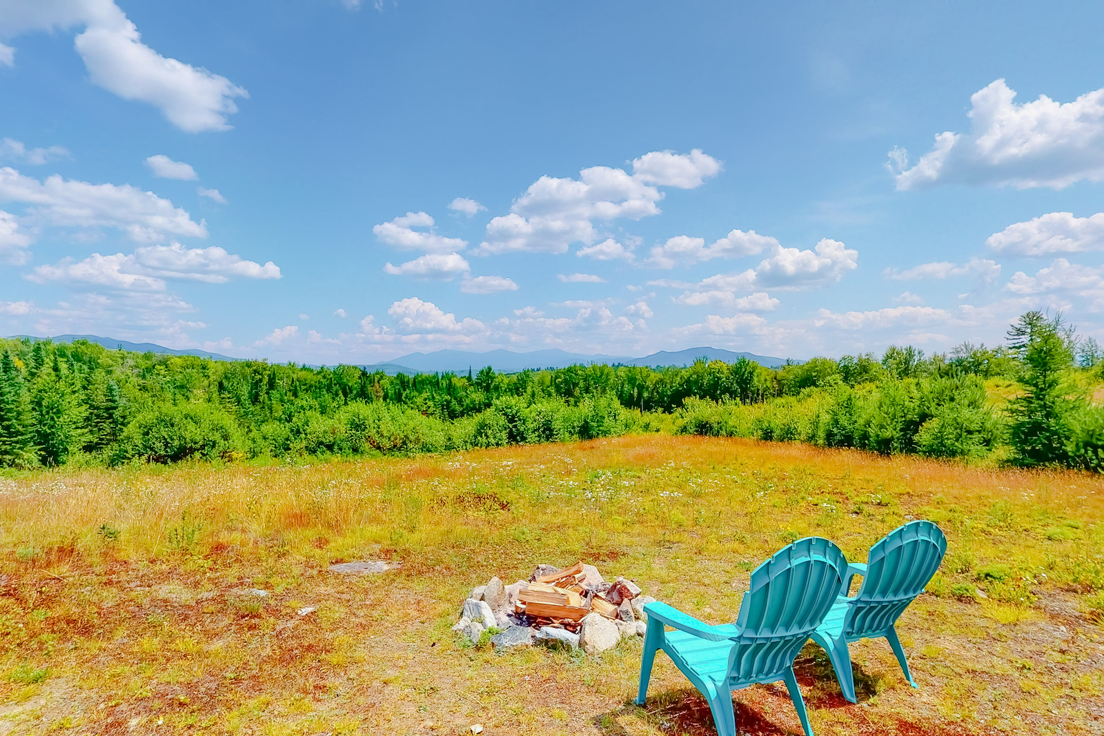 A firepit with chairs at a Lancaster vacation rental with open sky views.