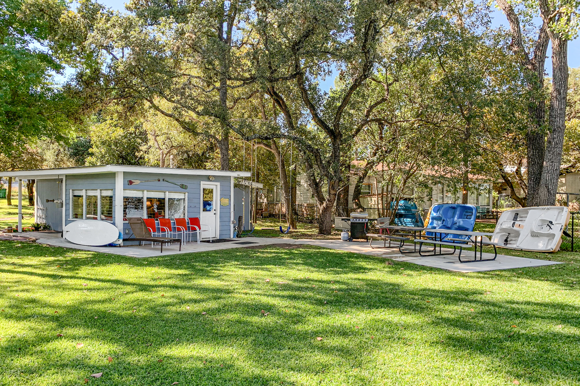 Large backyard with park benches and water activity equipment at a vacation home in Kingsland, TX
